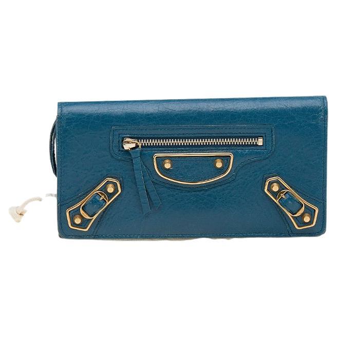 Whether you carry it on its own or in your handbag, this wallet from Balenciaga truly stands out with its unique design. It is crafted using leather along with bronze-tone hardware that lends it a sophisticated look. It features a pocket and stud