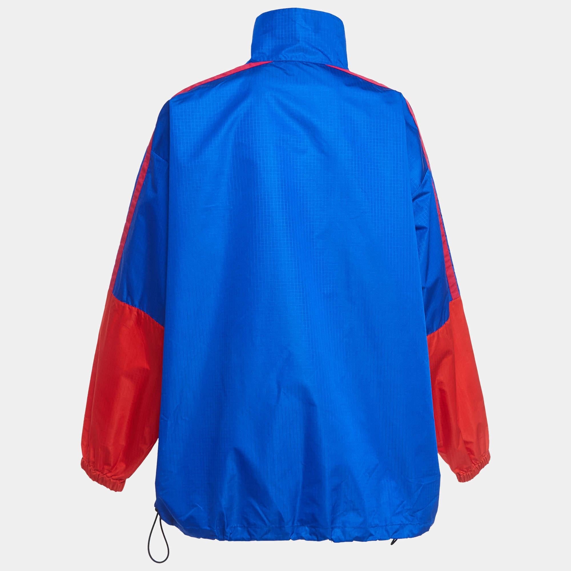 The Balenciaga jacket is a sleek and stylish outerwear piece. Crafted from high-quality synthetic materials, it features a bold blue and red color scheme with the iconic Balenciaga logo emblazoned across the chest. Perfect for adding a pop of color
