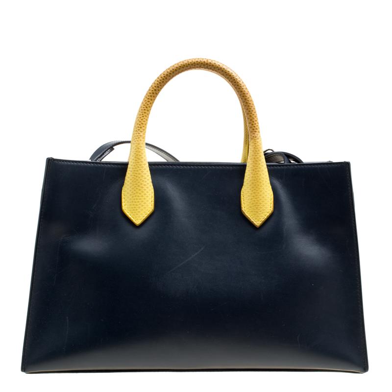 This Balenciaga bag definitely is a stunner in terms of its appeal and craftsmanship. Created from leather, the bag has a black shade with yellow handles and the label on the front. The bag is well-sized for sufficient carriage and it is complete