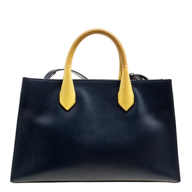 This Balenciaga bag definitely is a stunner in terms of its appeal and craftsmanship. Created from leather, the bag has a black shade with yellow handles and the label on the front. The bag is well-sized for sufficient carriage and it is complete