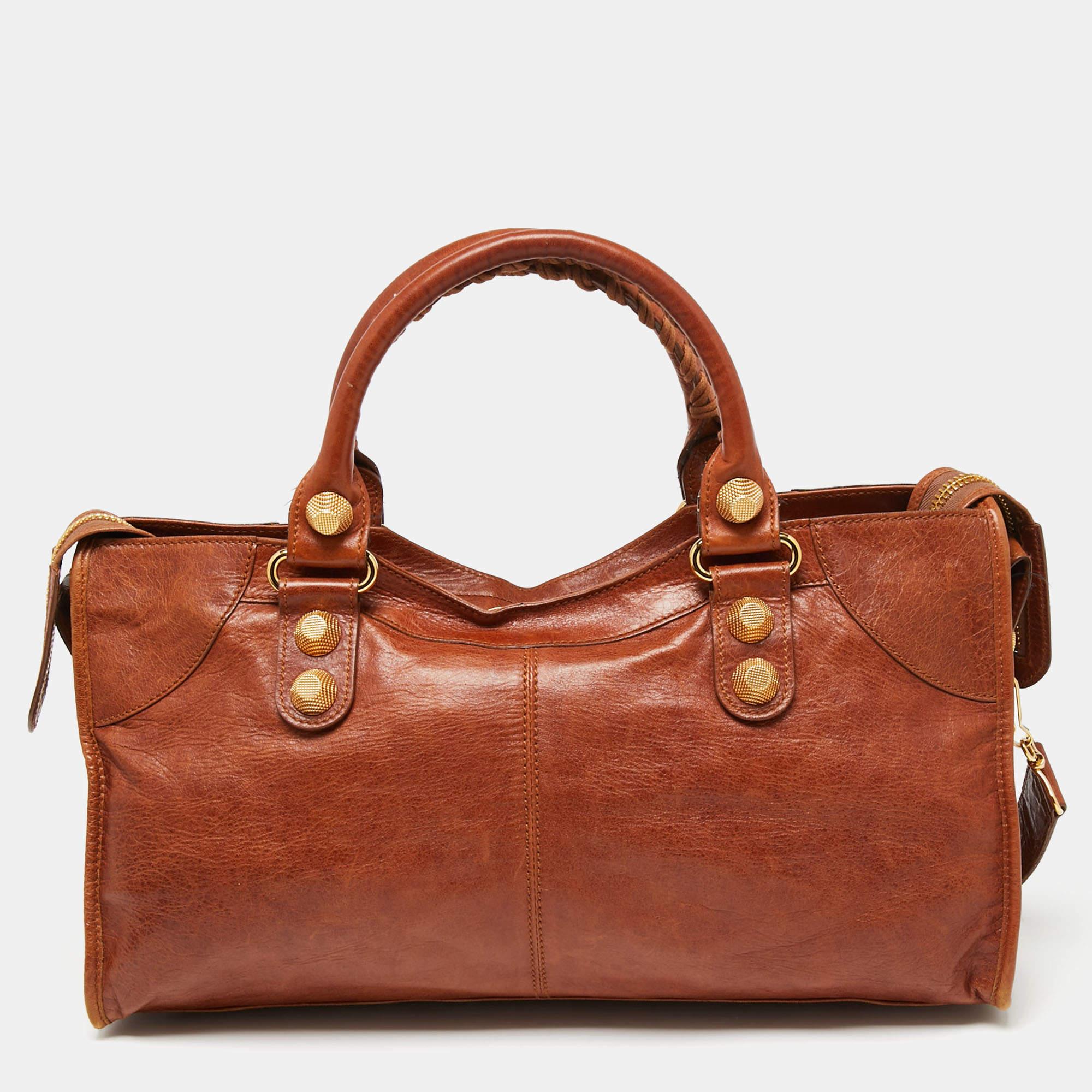 When in doubt, trust the classics. This Balenciaga GGH Part Time leather bag is offered in a delighting brown. The timeless silhouette is paired with gold-tone hardware and fitted with two top handles and a shoulder strap. Make a worthy investment