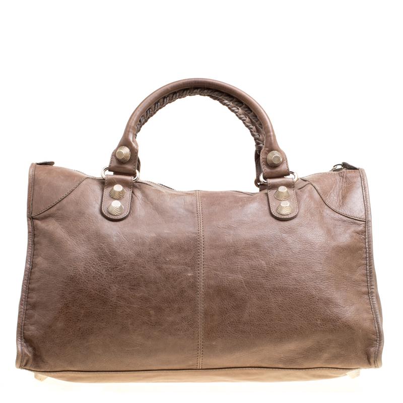 This Balenciaga GH work tote is perfect for everyday use. Crafted from leather in a gorgeous brown hue, the bag has a feminine silhouette with two top handles and silver-tone hardware. The zipper closure opens to a fabric-lined interior and the bag