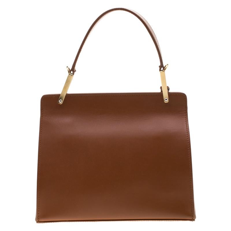 This structured beauty belongs to Balenciaga's Fall-Winter 2013 collection. This Le Dix Cartable is crafted from brown leather into a lovely silhouette with a front flap. It is secured with a gold-tone lock that opens to a leather-lined interior