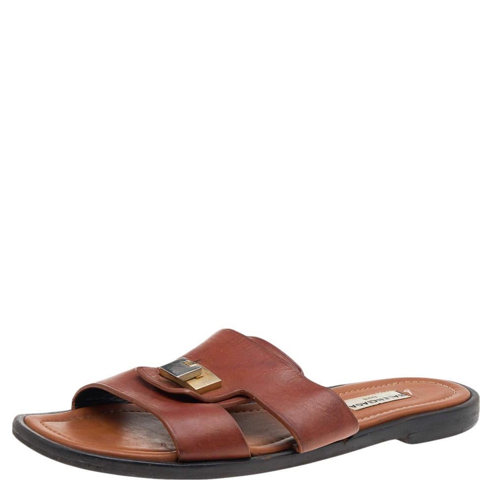 These slide sandals from the House of Balenciaga are made to adorn your feet. Crafted from brown leather, they come with a gold-tone accent on the upper strap. These sandals have a slip-on style and are perfect for everyday use. 