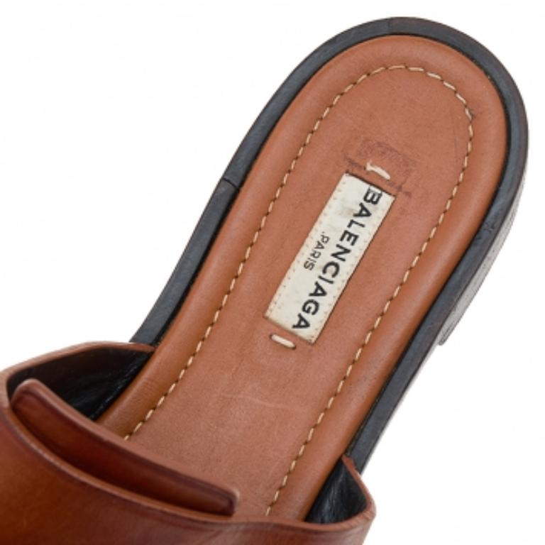 Diese Pantoletten aus dem Hause Balenciaga sind wie geschaffen, um Ihre Füße zu schmücken. Sie sind aus braunem Leder gefertigt und verfügen über einen goldfarbenen Akzent am oberen Riemen. Diese Sandalen sind zum Hineinschlüpfen und eignen sich