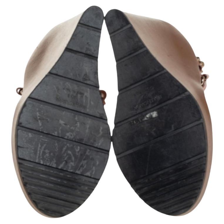 These leather sandals are edgy, look fashionable, and chic. With broad vamps and studded ankle straps, these sandals are made to offer you maximum style. These sandals from Balenciaga are complete with high wedge heels. Wear these beautiful brown
