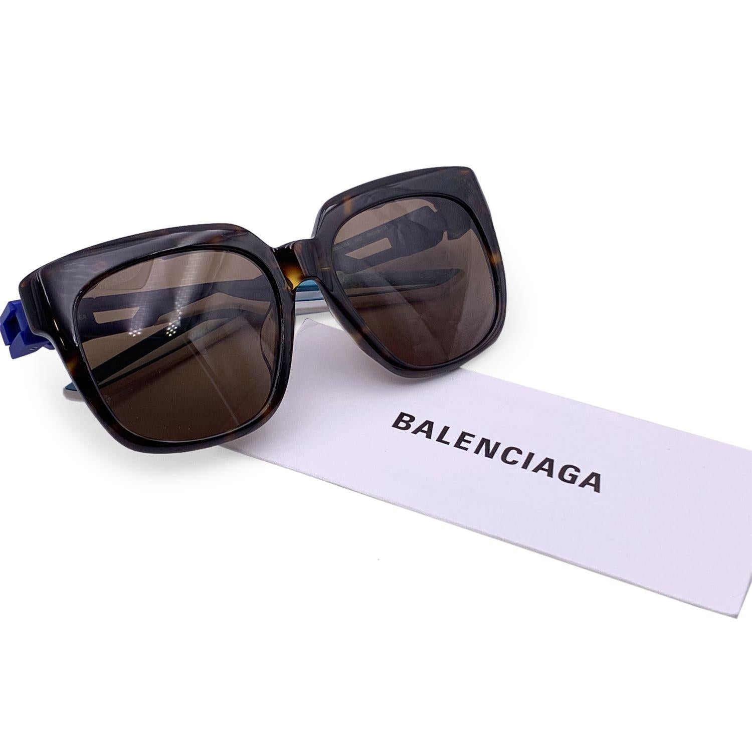 Balenciaga TripleS BB0025S sunglasses in color 002 brown. Squared brown havana acetate frame and brown lenses. Blue and white rubber effect temples with a black logo. Mod & refs: BB0025SA - 002 - 55/19 - 135. Made in Italy Details MATERIAL: Plastic