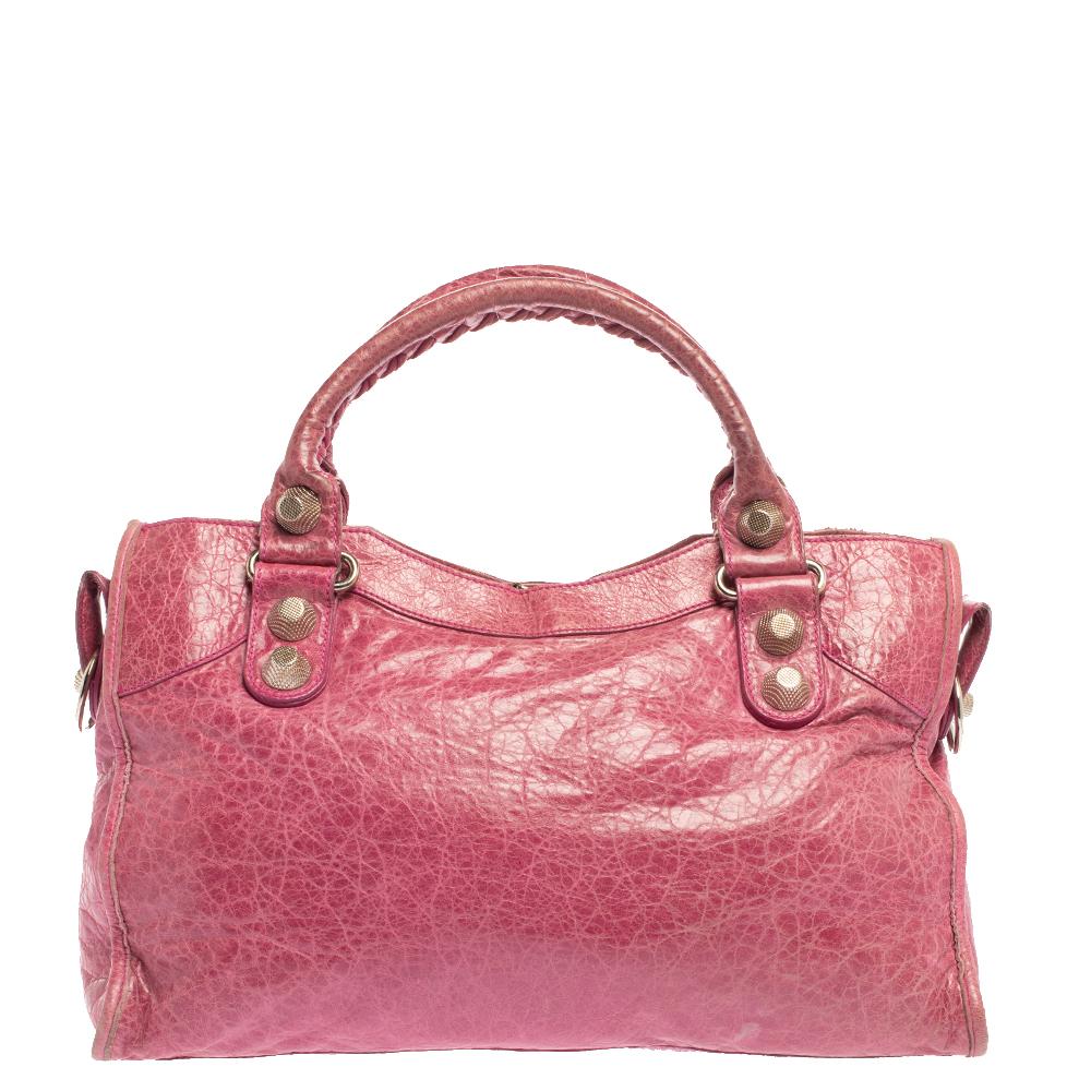 Die SGH City-Tasche von Balenciaga ist sehr elegant. Sie ist aus rosafarbenem Leder gefertigt und verfügt über zwei Griffe an der Oberseite, einen Reißverschluss an der Vorderseite, Schnallen und Nieten sowie ein mit Stoff gefüttertes Innenfach, in