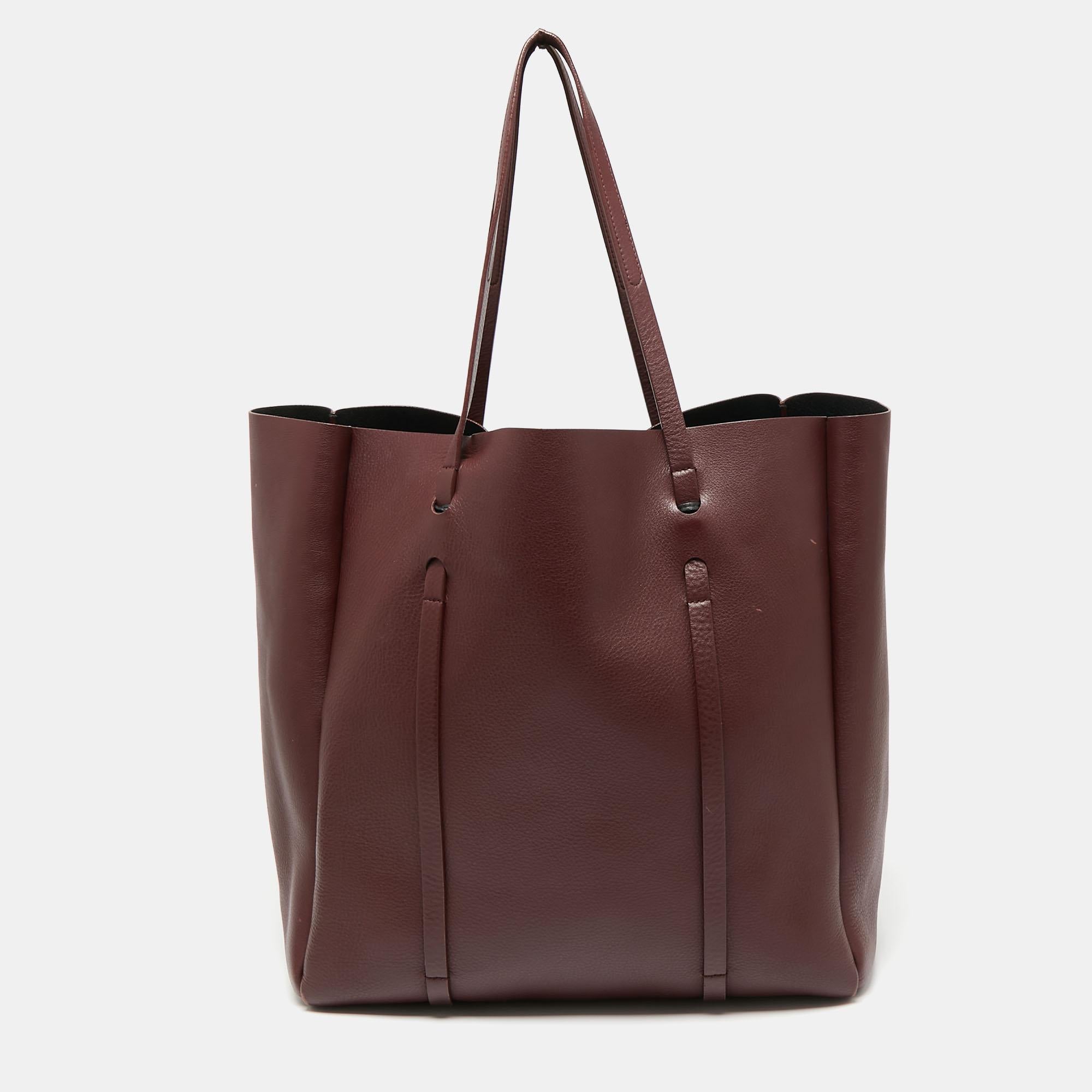 As the name suggests, this Everyday tote from Balenciaga is perfect for everyday use. Crafted from burgundy leather, the bag features two shoulder straps and the brand logo on the front. The tote opens to a spacious leather-lined interior that has