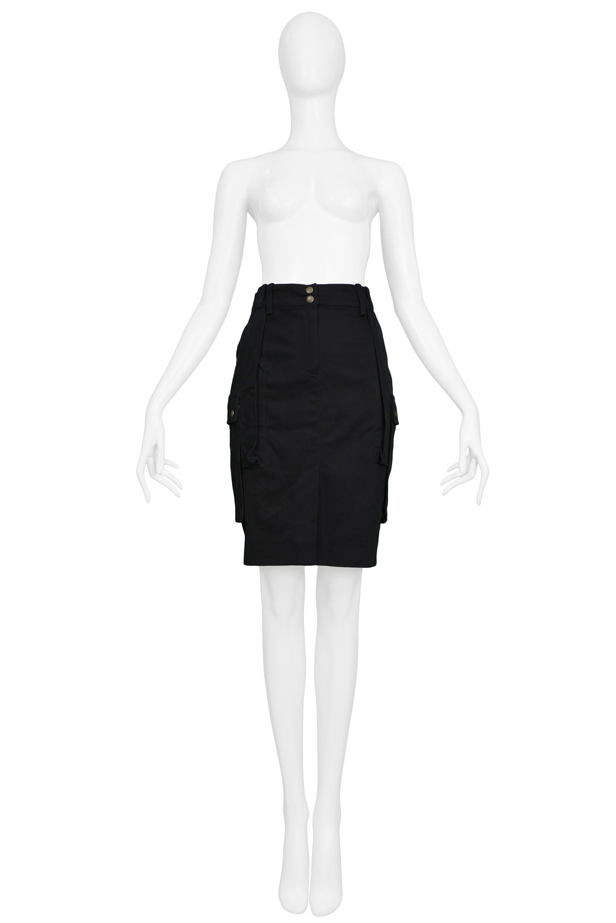 Resurrection Vintage is excited to offer of vintage Balenciaga by Nicolas Ghesquière black fitted cargo skirt featuring a high structured waistband, brass snaps, belt loops, a pencil style silhouette, large side cargo pockets with brass snaps, and