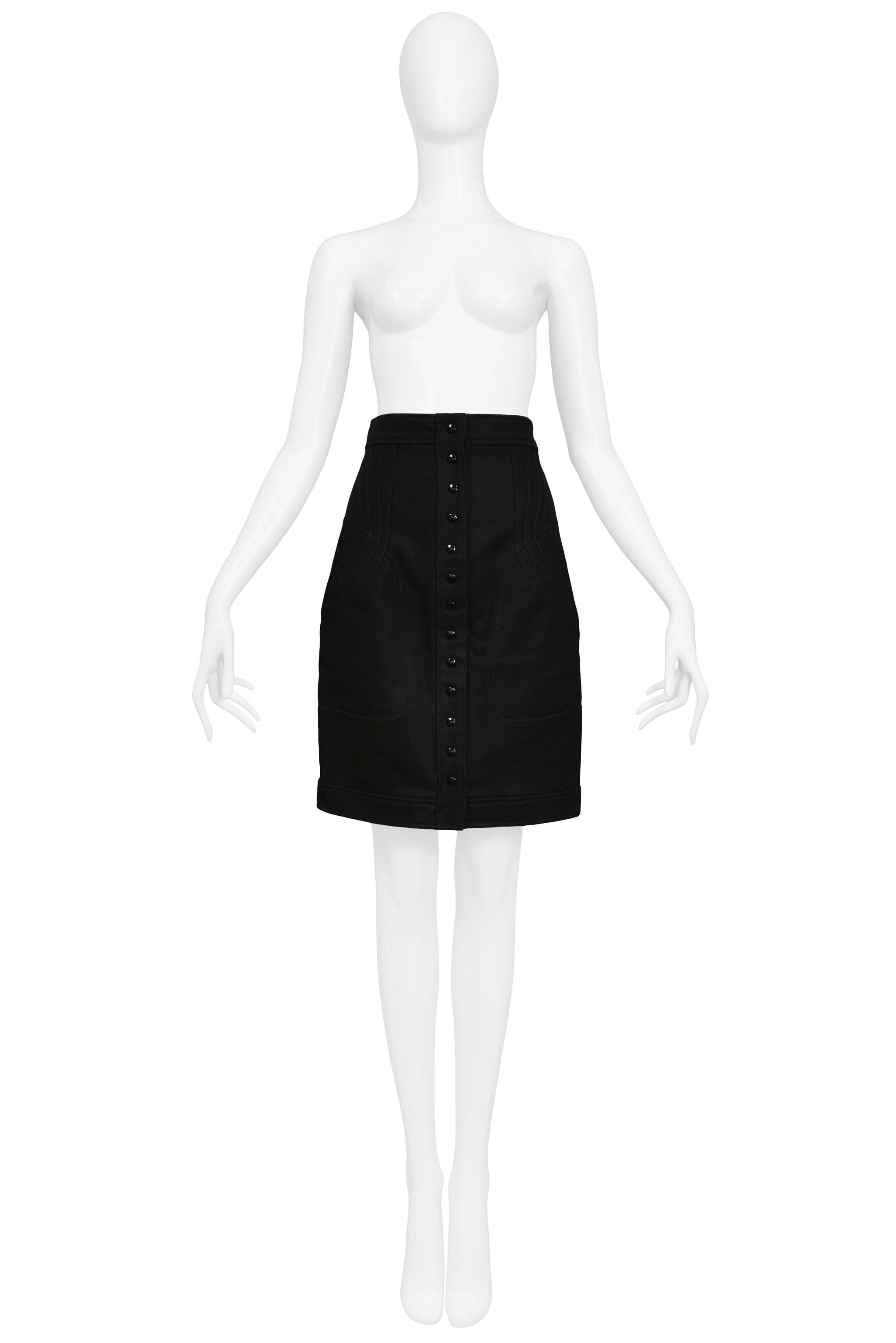 Resurrection is pleased to offer a vintage Balenciaga by Nicolas Ghesquiere black wool pencil skirt featuring a structured waistband, center front snaps, dramatic front and back darts and seaming, side pockets, and flat back. 

Balenciaga