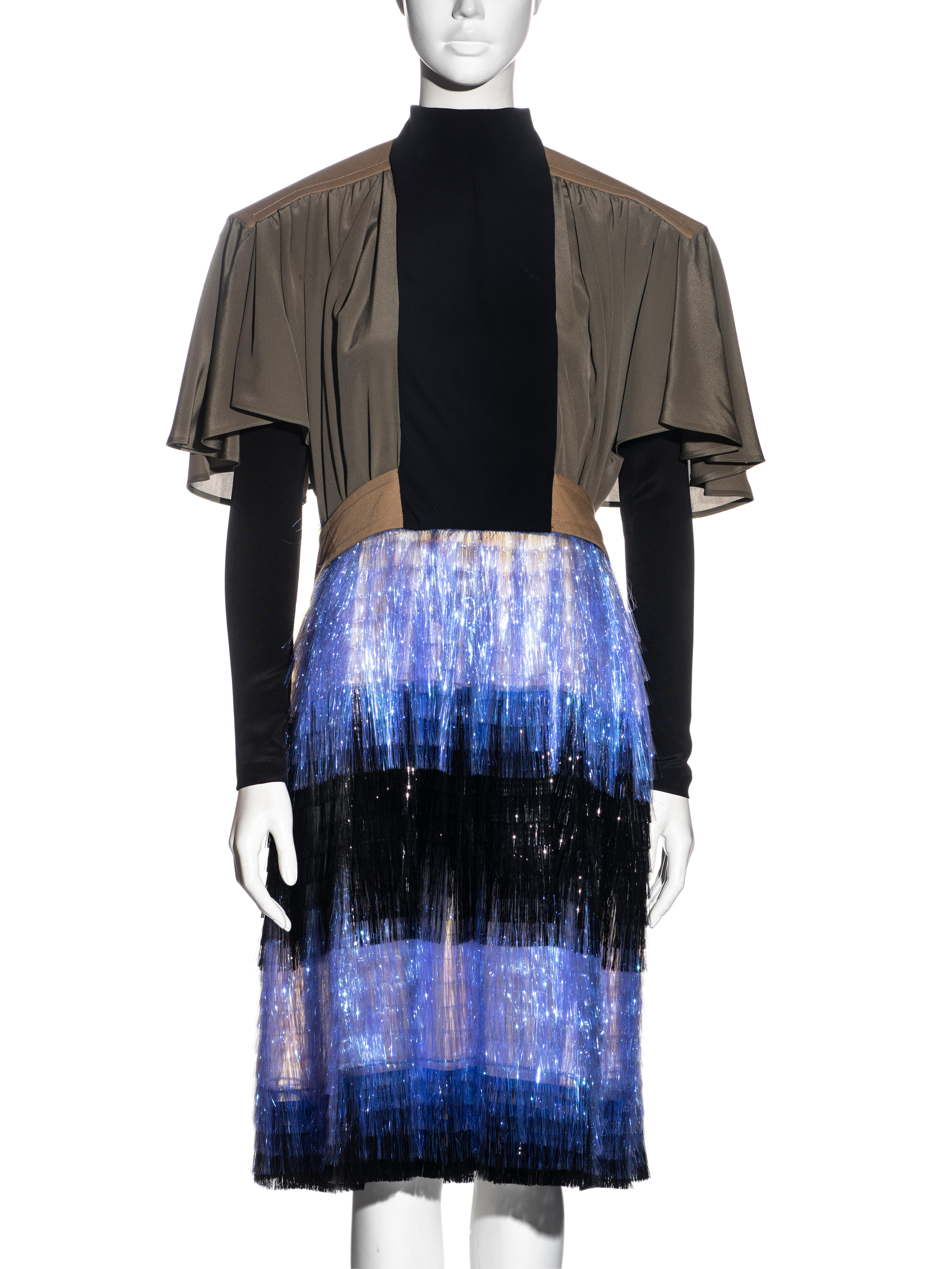 ▪ Rare Balenciaga mixed media dress
▪ Designed by Nicholas Ghesquière
▪ Extended shoulders
▪ Wide short sleeves with long fitted black sleeves underneath 
▪ Cotton belt hangs loosely a the back 
▪ Purple and black lurex fringe skirt 
▪ FR 36 - UK 8