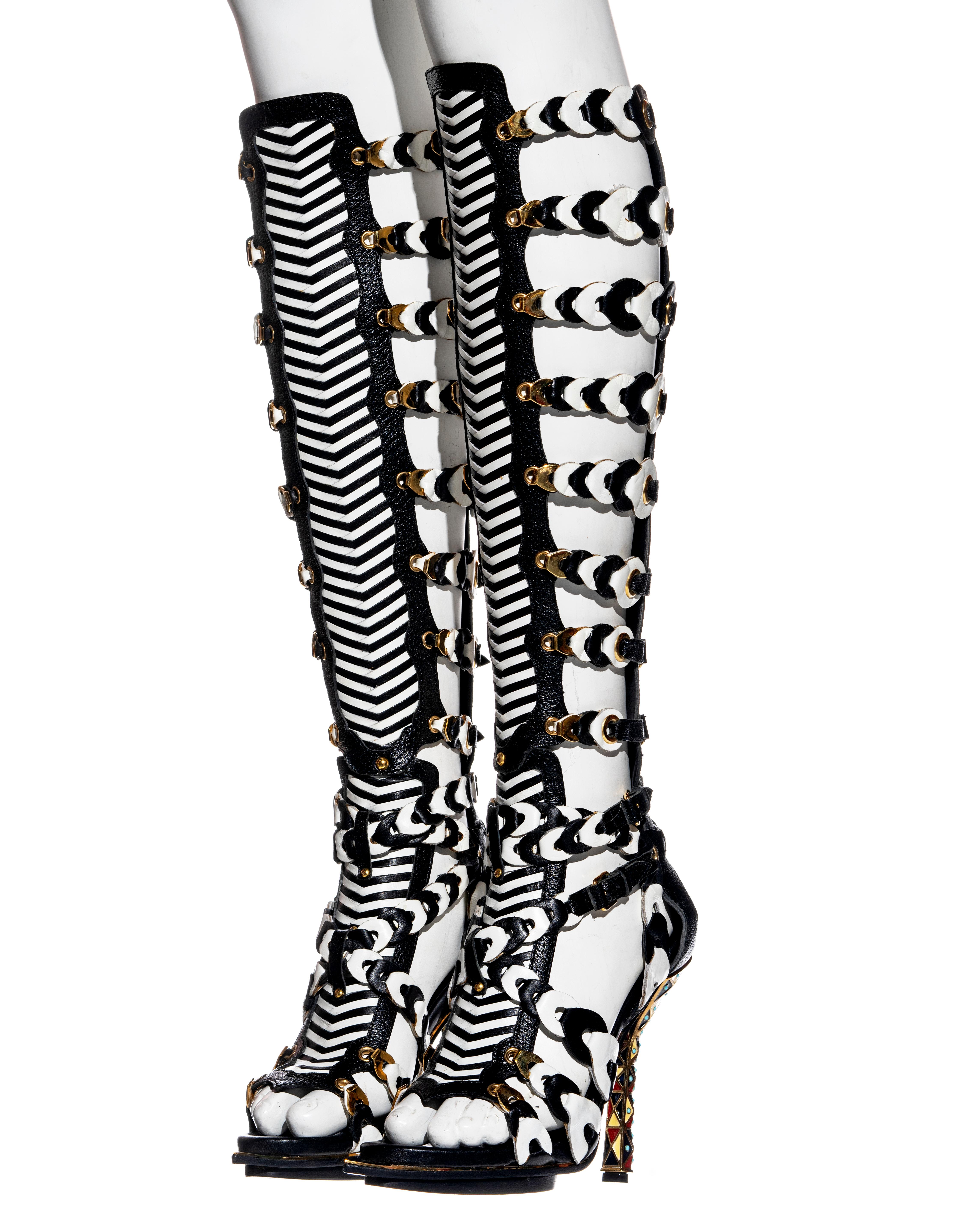 ▪ Important Balenciaga black and white woven leather gladiator sandals
▪ Designed by Nicolas Ghesquière
▪ Gold metal hardware 
▪ Multiple buckled strap fastenings 
▪ Pointed open toe with gold mirrored detail 
▪ Cloisonné bejeweled heels
▪ Size