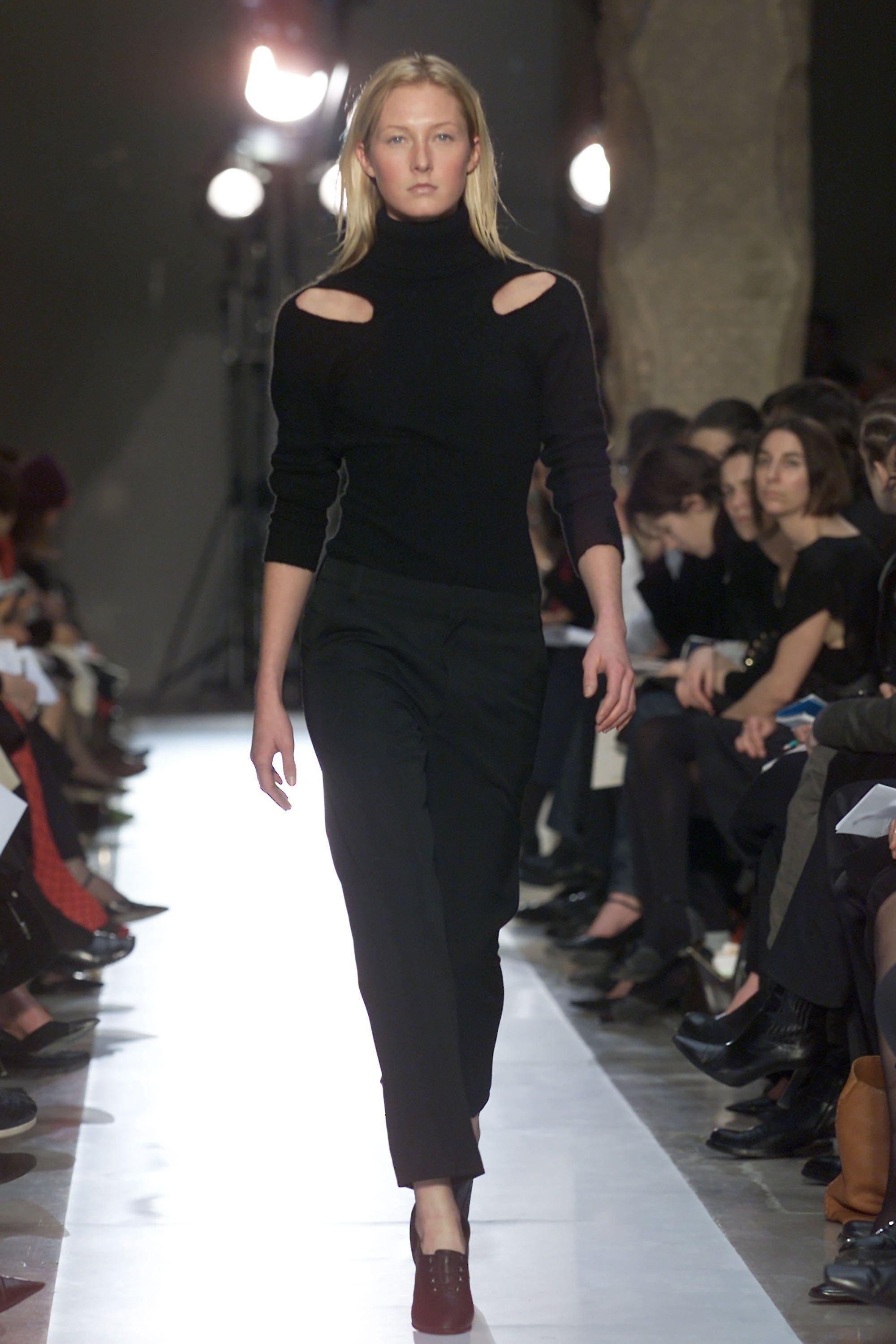 Questo maglione per la sfilata dell'autunno 2001, che risale agli esordi rivoluzionari di Nicolas Ghesquière a Balenciaga, cattura l'istinto dello stilista per il minimalismo scultoreo e la sovversione sensuale. Realizzato in lana nera, è lavorato