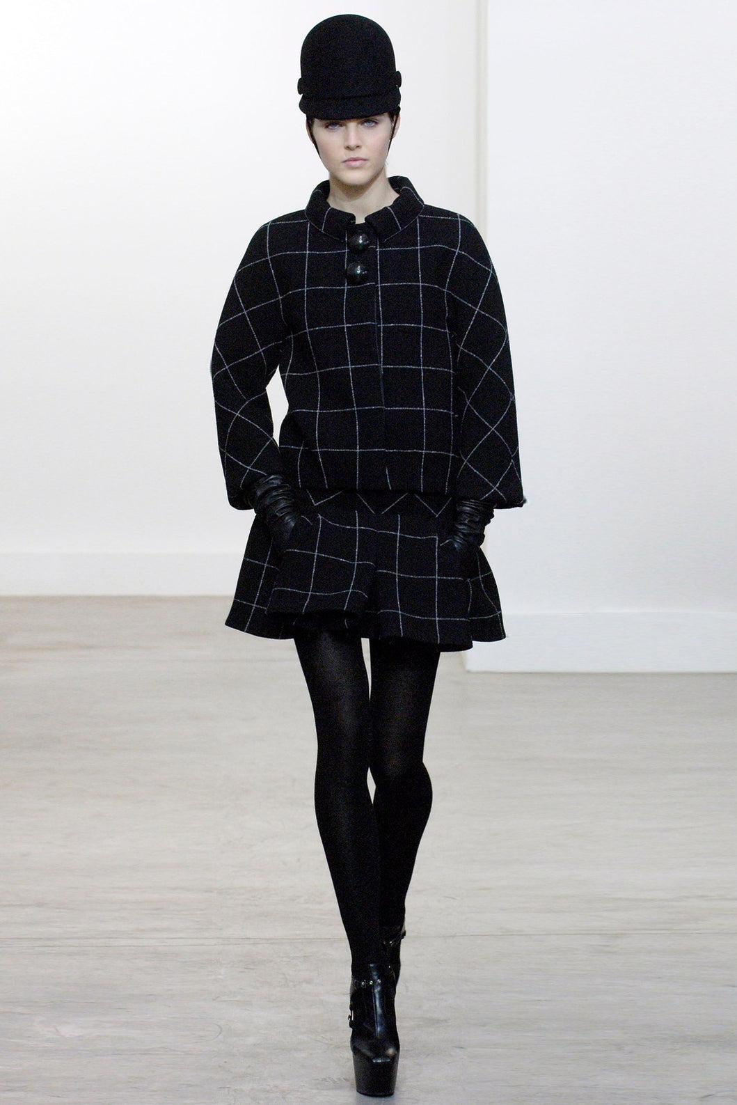 From the Fall/Winter 2006 runway, this striking two-piece windowpane ensemble is a modern homage to the house’s 1960s couture heritage. A celebrated look from one of Ghesquière’s defining collections, this silhouette is also held in the permanent