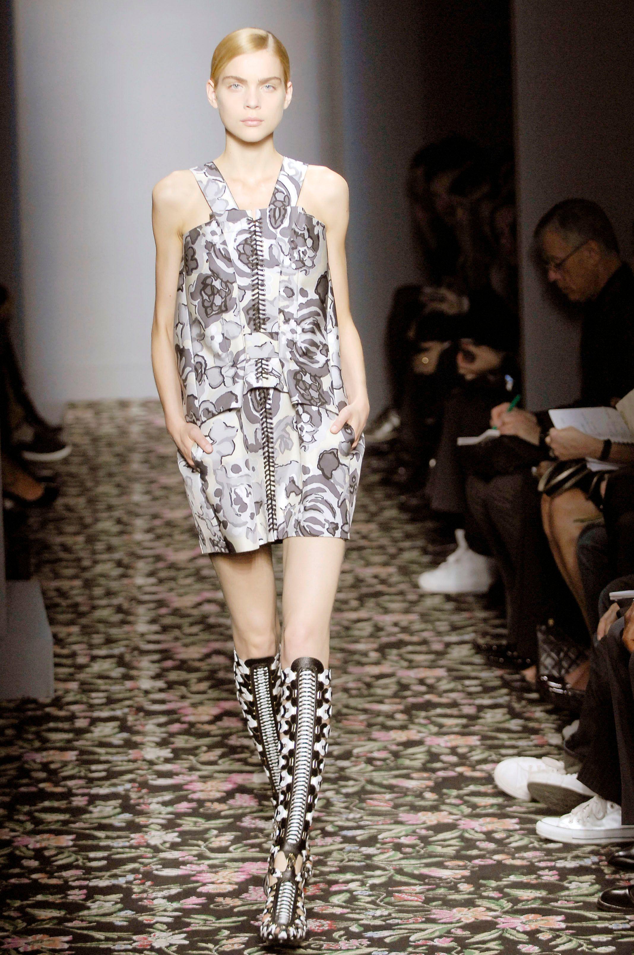 Une pièce d'archive saisissante issue de la collection futuriste Printemps 2008 de Nicolas Ghesquière pour Balenciaga. Ce dos nu sculptural met en valeur le néoprène collé, signature de la collection, associé à des fleurs picturales inspirées des