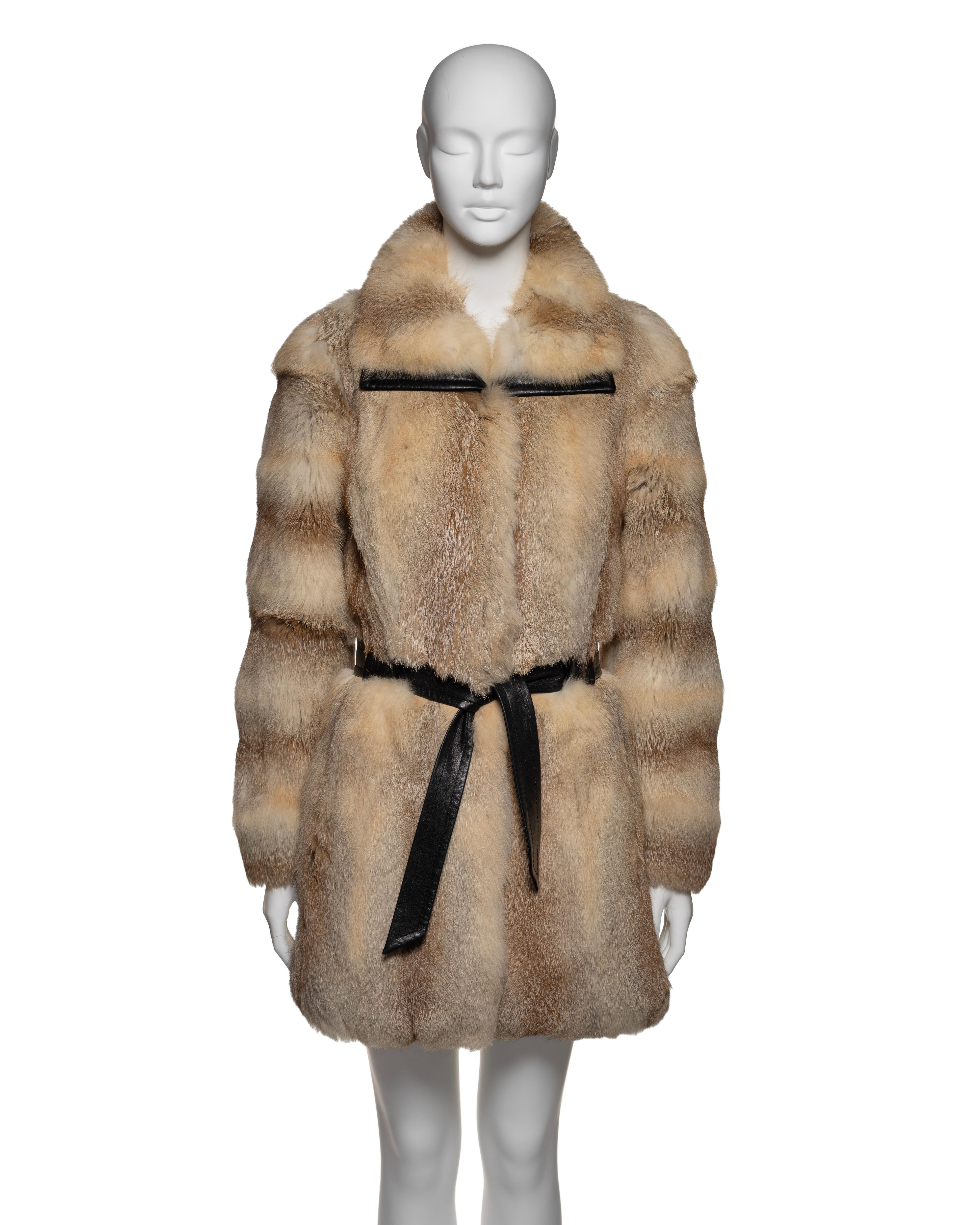 This Balenciaga by Nicolas Ghesquière fox fur coat features horizontal bands of tan and beige fox fur, giving it a distinctive striped appearance. The coat is belted at the waist with lambskin leather accents on the belt and trims, adding contrast