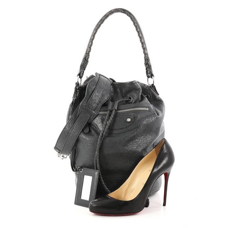 This authentic Balenciaga Carly Giant Studs Handbag Leather showcases the brand's bold and playful style. Crafted from supple dark gray leather, this bucket bag features a looped handle with whipstitch details, exterior front zip pocket, signature
