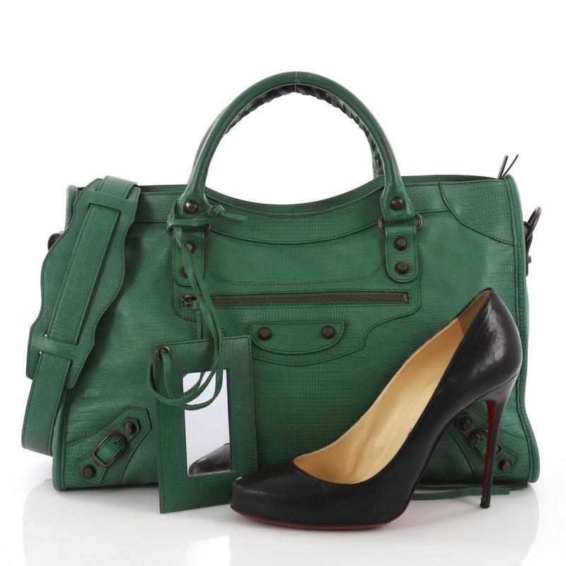 This Balenciaga City Classic Studs Handbag Lizard Embossed Leather Medium, crafted in green lizard embossed leather, features dual braided woven handles, front zip pocket, iconic classic studs and brass-tone hardware. Its top zip closure opens to a