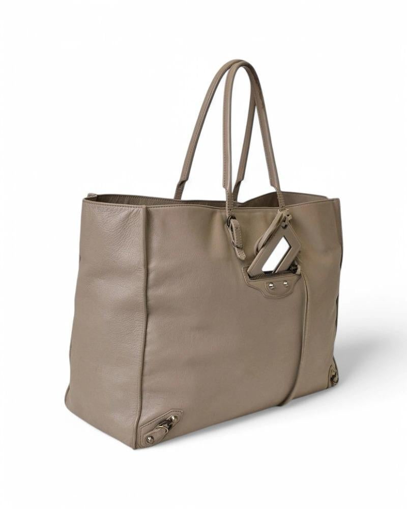 Bag signed Balenciaga, model City Papier A4, made of smooth leather in beige color with bronze hardware. It has no closure, internally lined in tone-on-tone suede and leather with convenient pockets, the bag is very roomy. Equipped with double