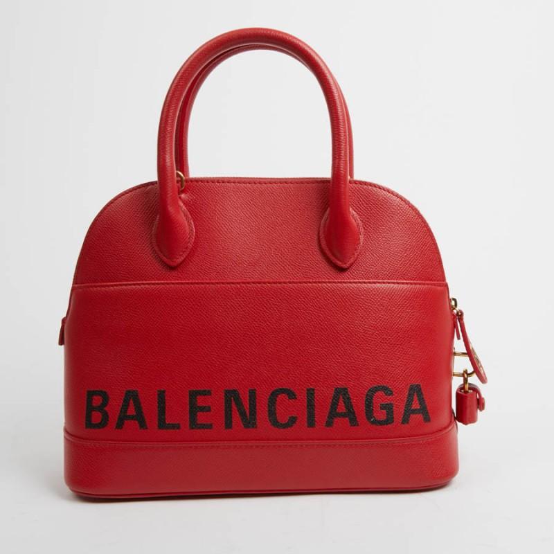 Top Handle City bag in poppy red grained calfskin, size S. Golden metal hardware, can be carried by hand or on the shoulder. Zipped closure, lined in red leather and yellow fabric. It has two flat pockets, one of which is zipped. On both sides of