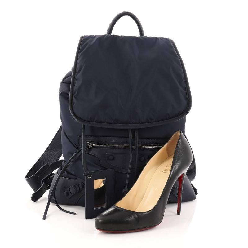 This authentic Balenciaga Classic Traveller Backpack Nylon with Leather showcases an urban-ready look and supreme functionality. Crafted in navy blue nylon with navy blue leather trims, this bag features a braided top handle, adjustable shoulder