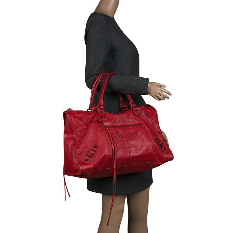 This Balenciaga City RH tote is perfect for everyday use. Crafted from leather in a gorgeous red hue, the bag has a feminine silhouette with two top handles and bronze-tone hardware. The zipper closure opens to a fabric-lined interior and the bag is