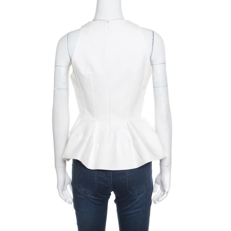 This cream Balenciaga top is made of 100% cotton and is a perfect blend of comfort and style! It features a sleeveless peplum silhouette and is sure to lend you a great fit. It comes equipped with a concealed zip closure at the back and can be