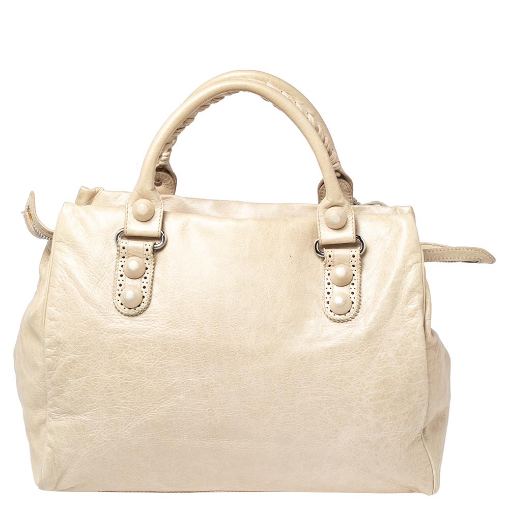 Recognized as a globally popular creation, this Giant 21 Midday bag from Balenciaga will never leave you unnoticed! It is crafted using cream lambskin leather on the exterior and flaunts silver-toned hardware, dual handles, and a fabric-lined