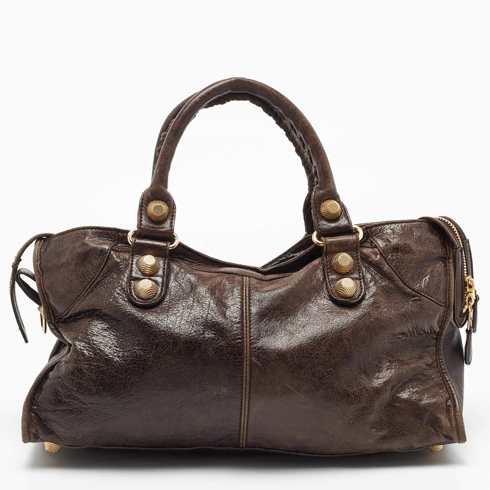 When in doubt, trust the classics. This Balenciaga GGH Part Time leather bag is offered in dark brown. The timeless silhouette is paired with gold-tone hardware and fitted with two top handles and a shoulder strap. Make a worthy investment with this