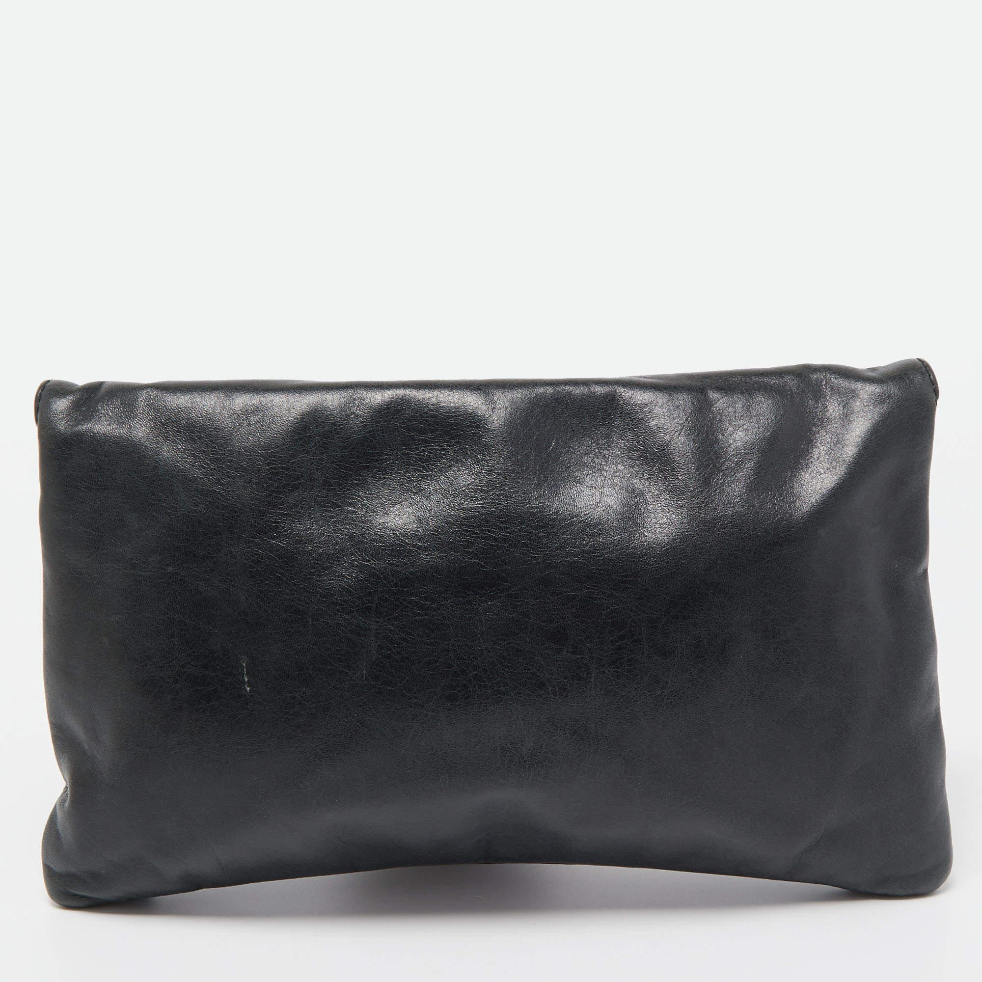 You will find yourself reaching out to this Balenciaga clutch more often because of its versatility. Crafted from leather, the folded top elevates its silhouette, and the gold-tone accents make it undeniably chic. The design is made functional with