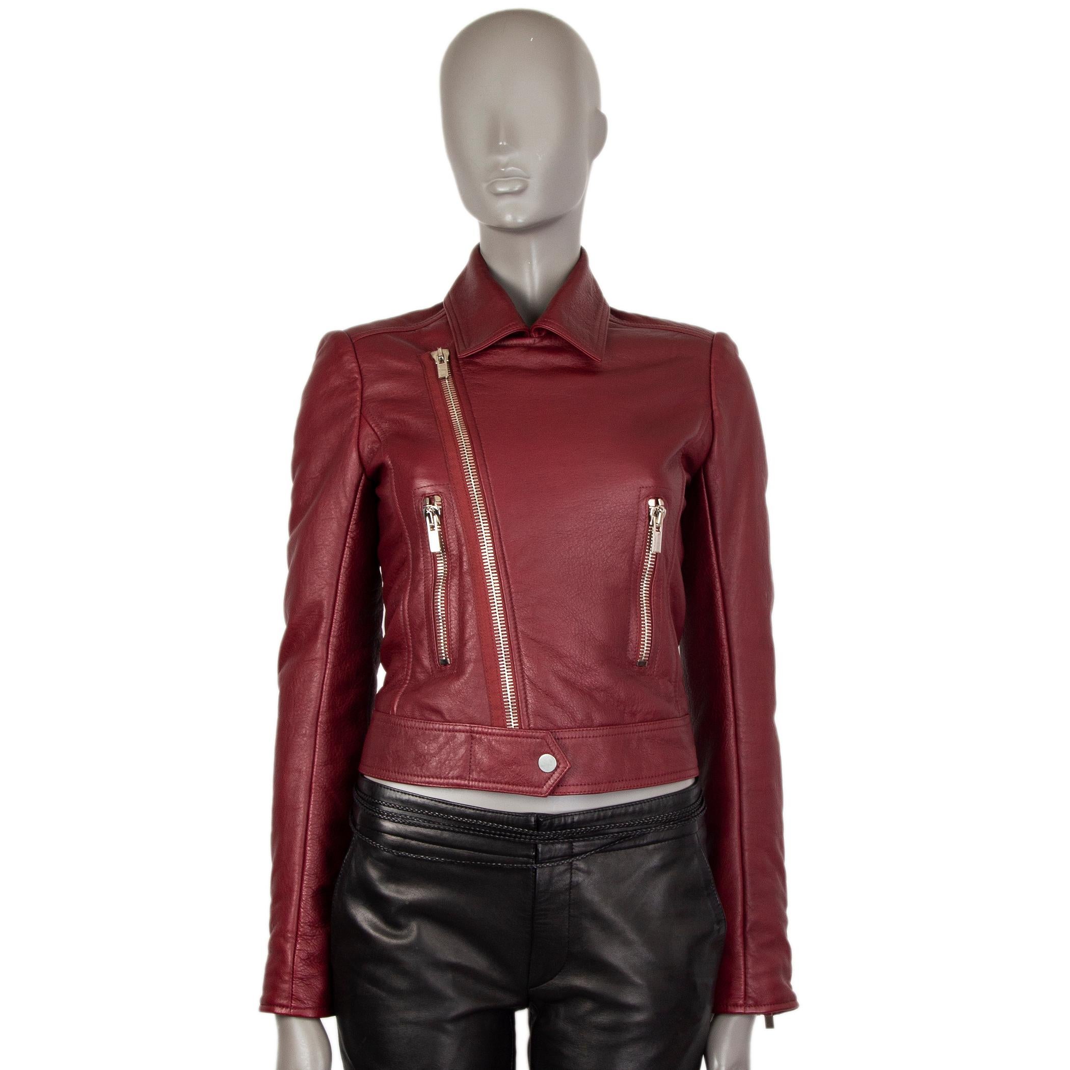 100% authentic Balenciaga biker jacket in dark red lambskin leather with zippers on the sleeves and two front zipper pockets. Closes with silver-tone zipper and snap on the front. Lined in black rayon (51%) and polyester (49%). Has been worn and is