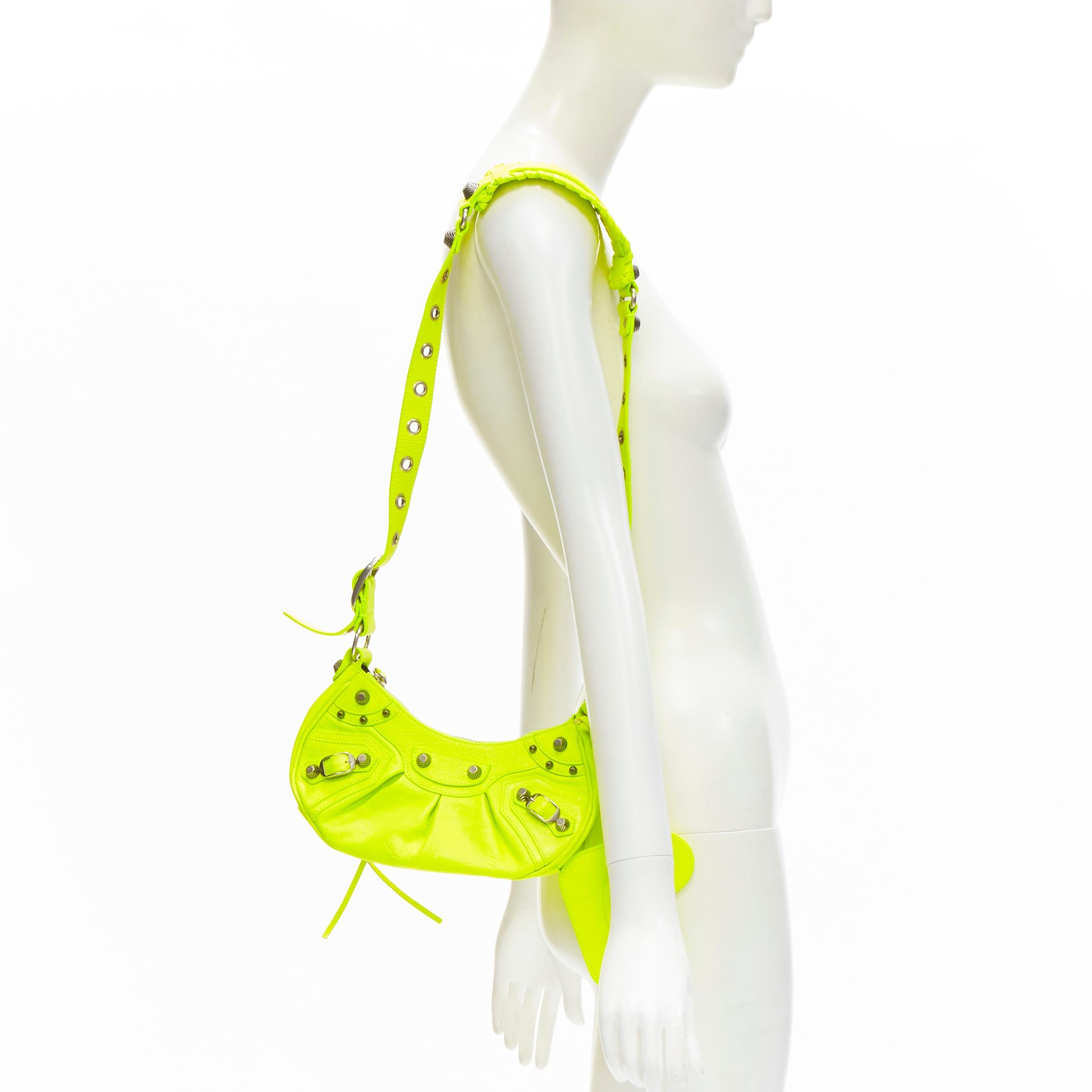 BALENCIAGA DEMNA LE Cagole XS neon yellow silver stud crossbody Motocross bag
Brand: Balenciaga
Designer: Demna
Model: Le Cagole XS
Material: Leather
Color: Yellow
Pattern: Solid
Closure: Zip
Extra Detail: Neon yellow crinkled leather. Antique