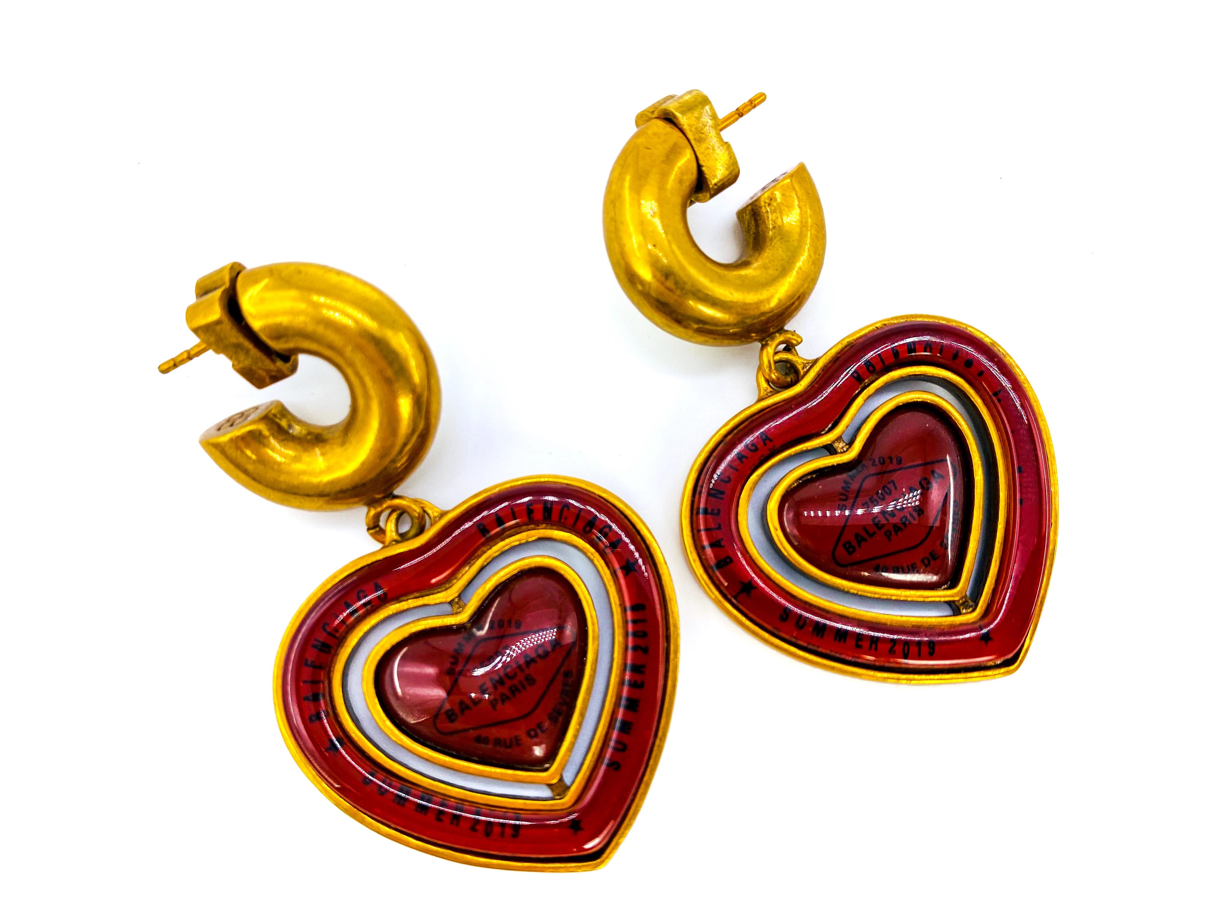 Balenciaga Preloved Statement Heart Earrings Summer 2019. 

Cast from red resin and antique gold metal and inspired by a Casino chip. These were featured in Balenciaga's iconic and awe inspiring SS19 runway show. This pair is further stamped with