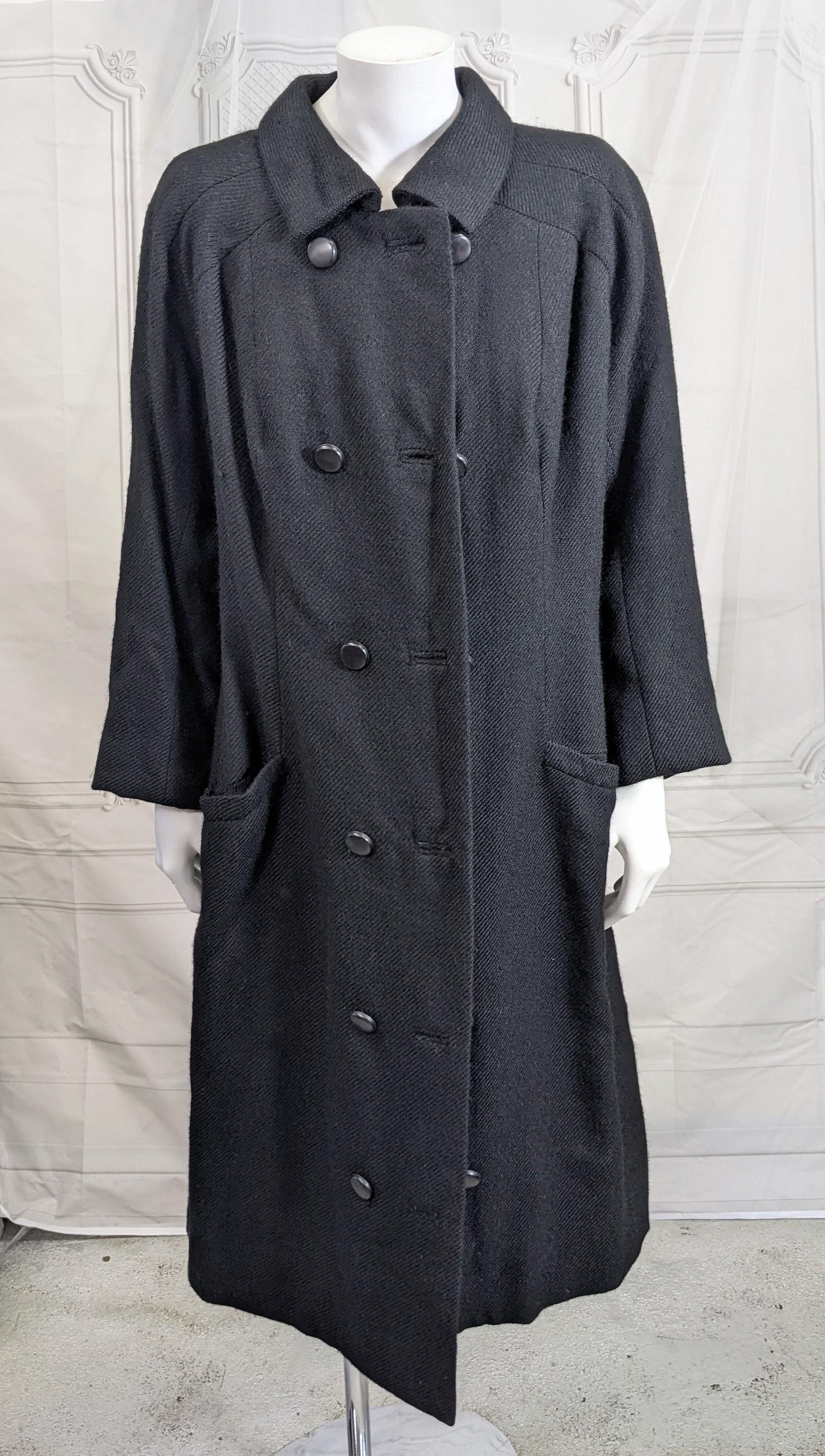 Eisa Balenciaga Haute Couture coat.  Double breasted black textured wool twill designed by Cristobal Balenciaga for Eisa dating to the early 1960's.
The semi fitted cut coat with buttons of black bakelite resin is fully lined in black silk.  Inset