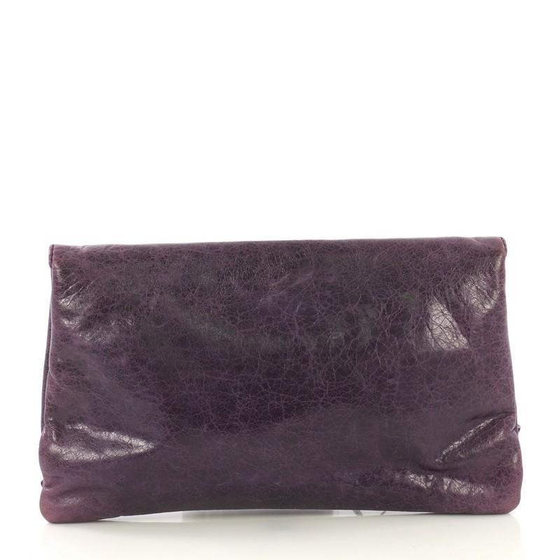 This Balenciaga Envelope Clutch Giant Studs Leather, crafted from purple leather, features signature giant metal studs with buckle details, exterior zip pocket, and silver-tone hardware. Its hidden magnetic snap closure opens to a black fabric