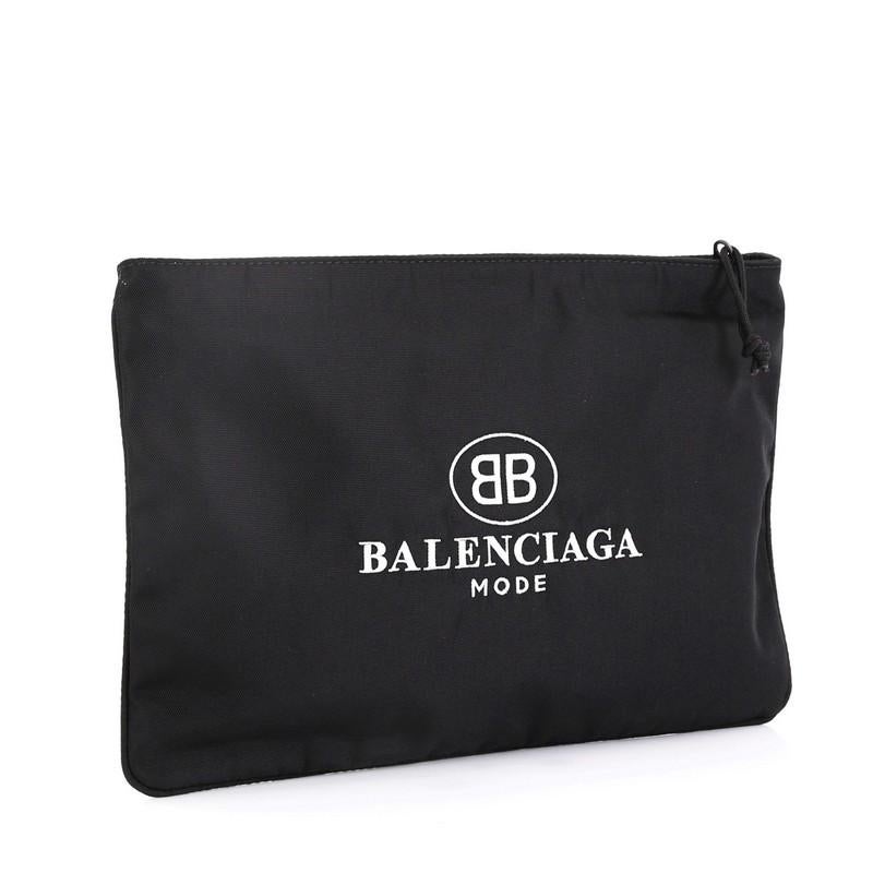 This Balenciaga Explorer Zip Pouch Embroidered Canvas Large, crafted in black canvas, features an embroidered BB Balenciaga logo print and matte gunmetal-tone hardware. Its zip closure opens to a black fabric interior. 

Condition: Excellent. Light