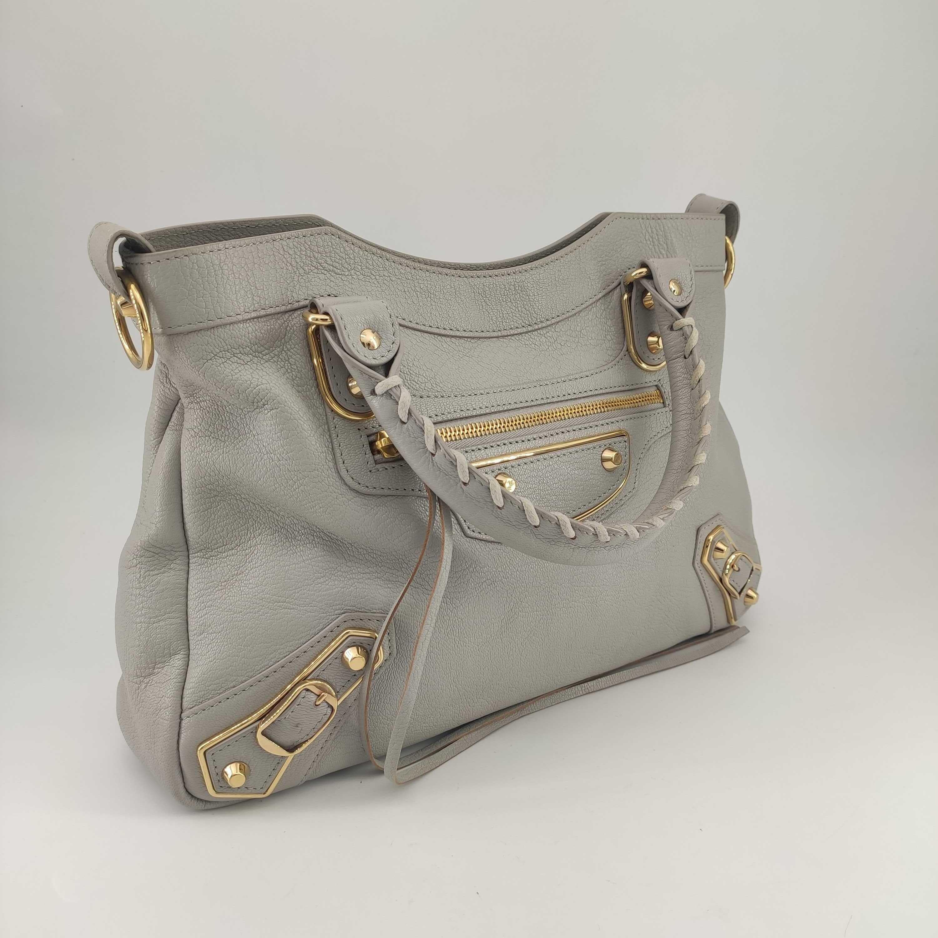 - Designer: BALENCIAGA
- Model: First
- Condition: Very good condition. 
- Accessories: None
- Measurements: Width: 32cm, Height: 23cm, Depth: 7cm, Strap: 58cm
- Exterior Material: Leather
- Exterior Color: Beige
- Interior Material: Cloth
-