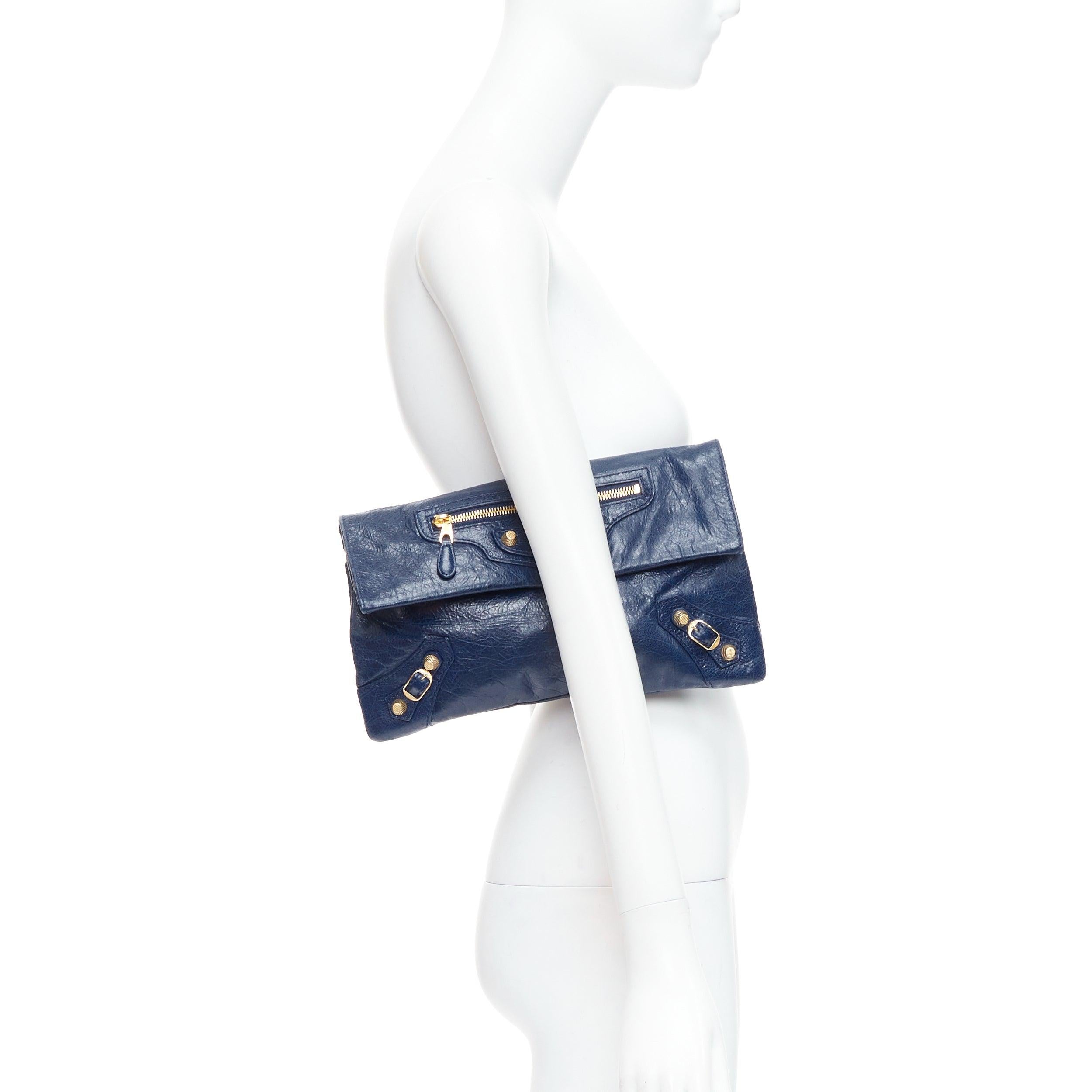 BALENCIAGA Giant 12 bleu mineral lambskin leather gold envelope clutch bag
Reference: ECLO/A00052
Brand: Balenciaga
Model: Giant 12
Material: Leather
Color: Blue, Gold
Pattern: Solid
Closure: Snap Buttons
Lining: Black Fabric
Extra Details: