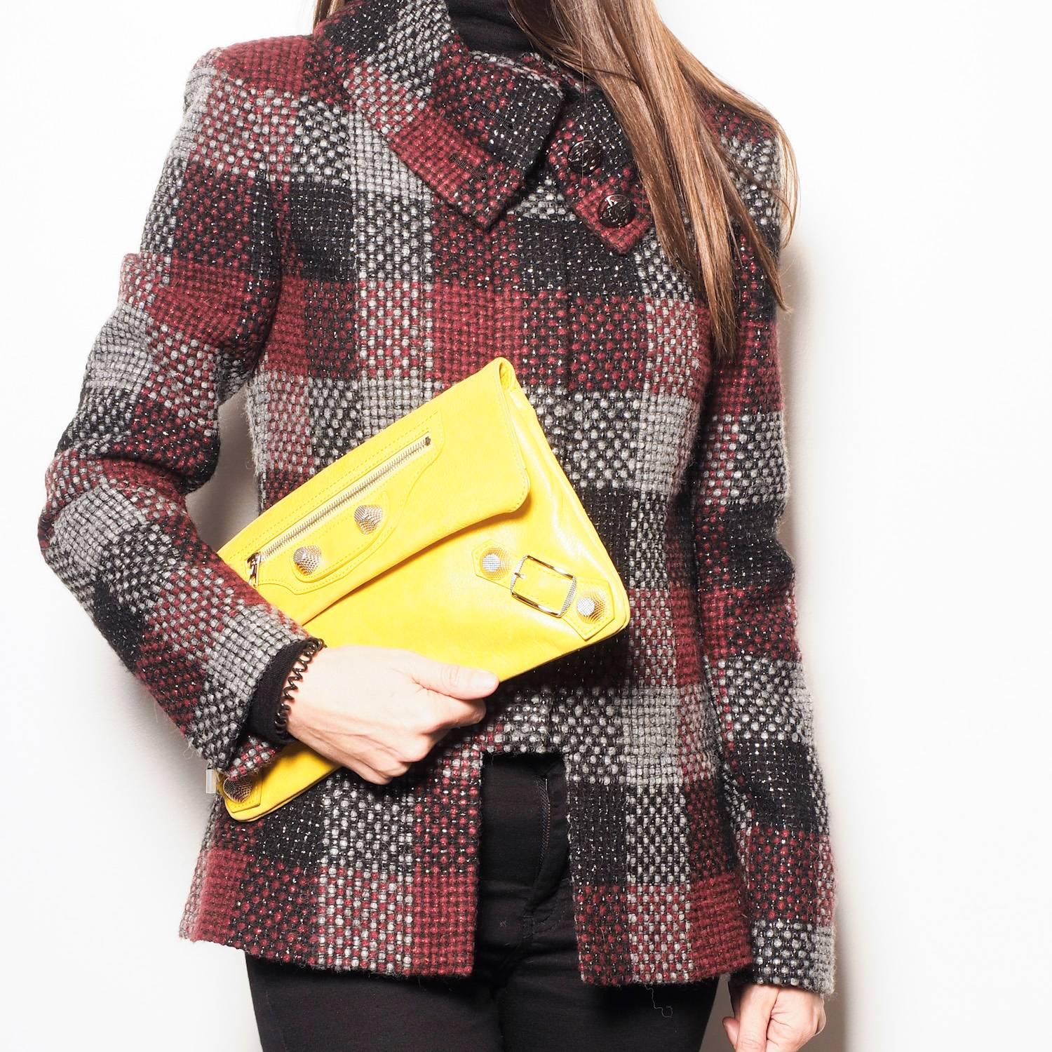 Balenciaga 'Giant Envelope' clutch in yellow leather. The interior is lined with black canvas. There is a large pocket closed by a snap button under the flap and two bellows and a mirror.

On the flap there is a zipper hiding a large pocket.

In