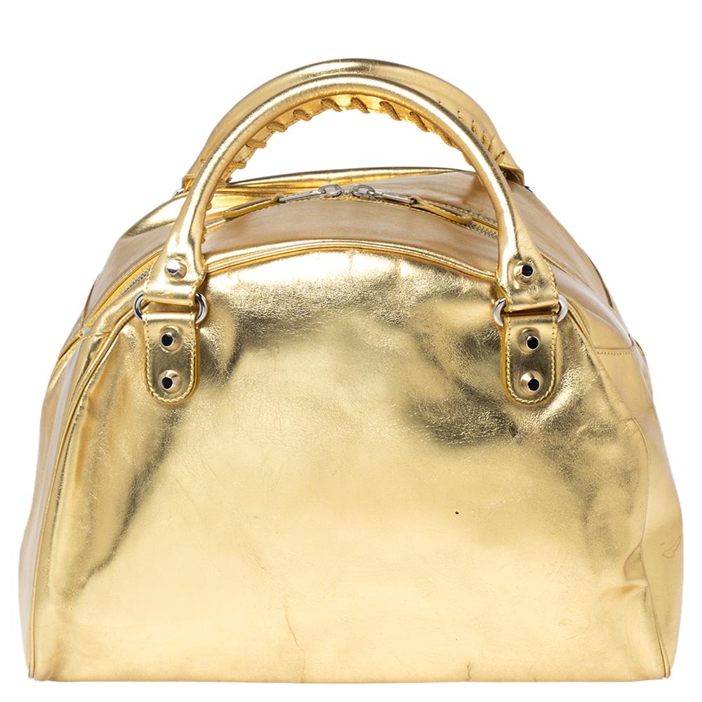 Finely crafted and meticulously designed, this Balenciaga bag is a must-have in every woman's closet. It is made from gold leather and features two handles, silver-tone hardware, and a zip closure that opens into a spacious interior. Ideal for any
