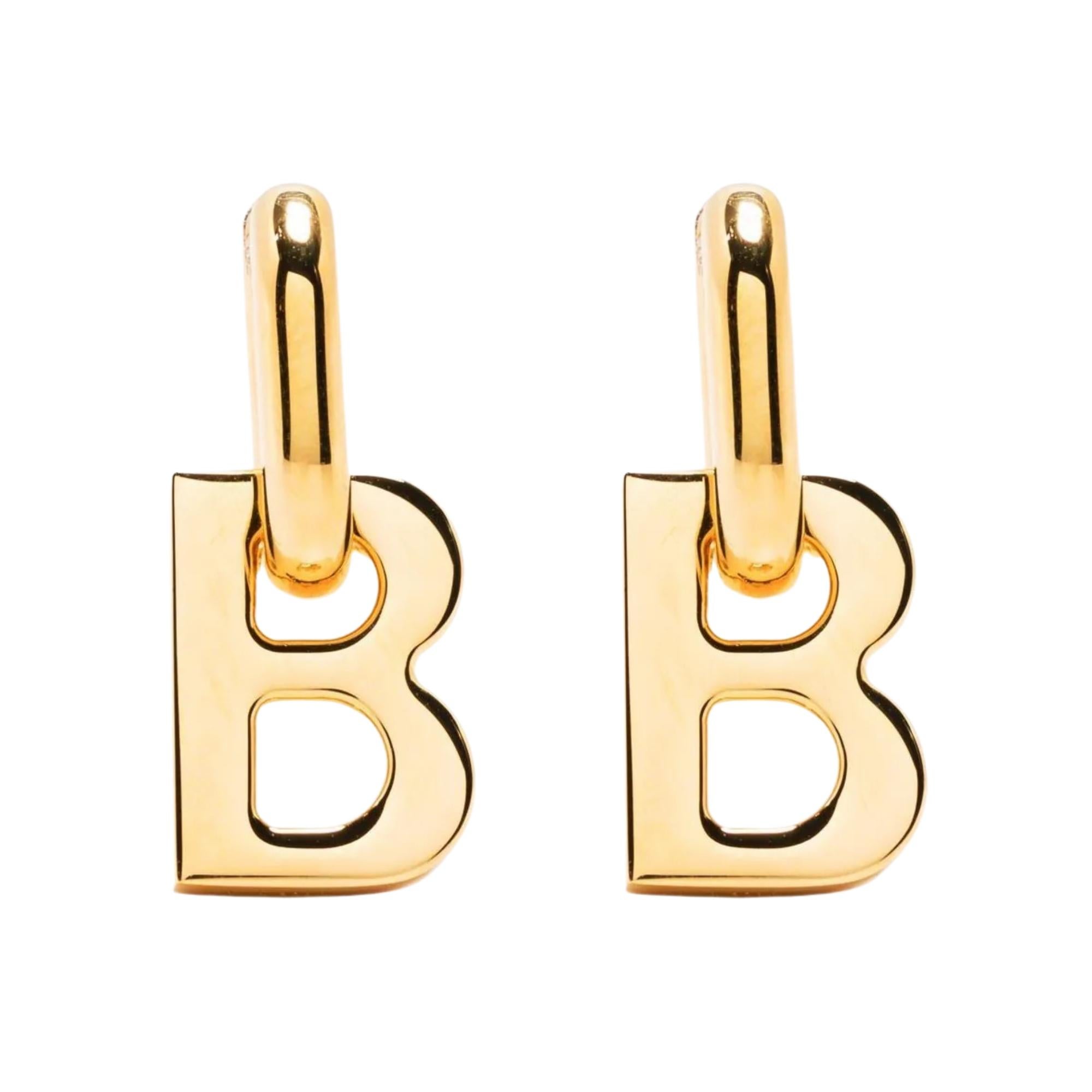 These Balenciaga drop earrings are constructed of gold-tone brass and feature a logo B pendant. The logo pendant is detachable at drop. Logo engraved at side. Hinged-post fastening.

Color: shiny gold tone
Material: Brass
Marks: Logo stamp & Made in