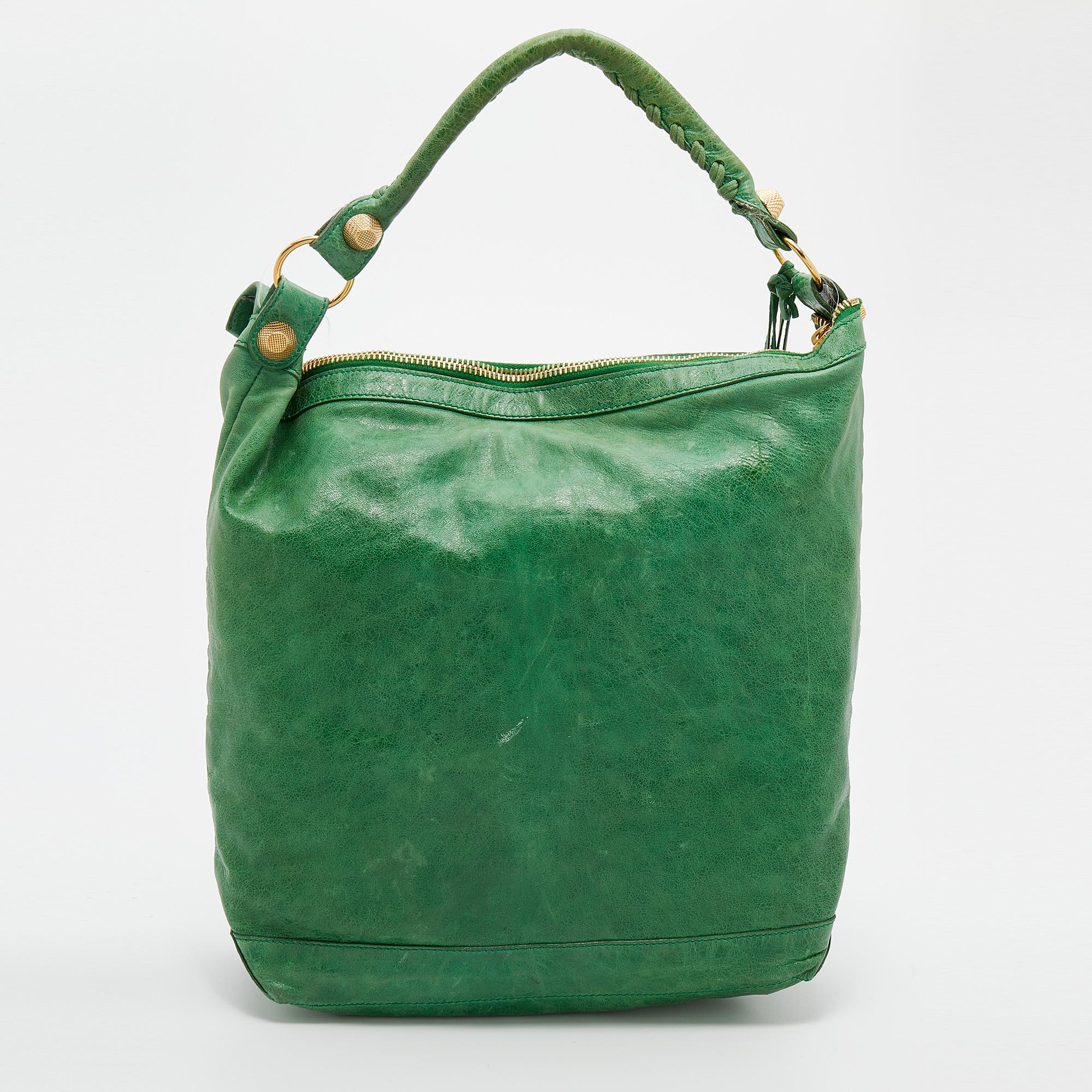 This Balenciaga Arena GGH Giant 21 Classic Day bag is perfect for everyday use. Crafted from leather in green, the bag has a classy silhouette with a top handle and signature accents in gold-tone hardware adorning the front. The zipper closure opens