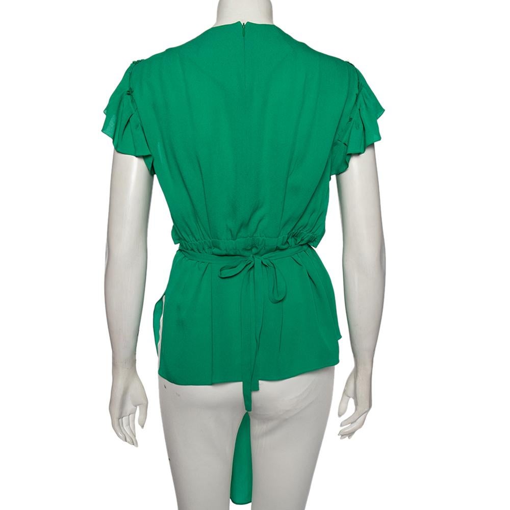 Escape the world of basic designs and transform your style into something better by wearing this blouse from Balenciaga. Made using green silk with pleated formations dominating the asymmetrical blouse, this creation remains classy and stylish in