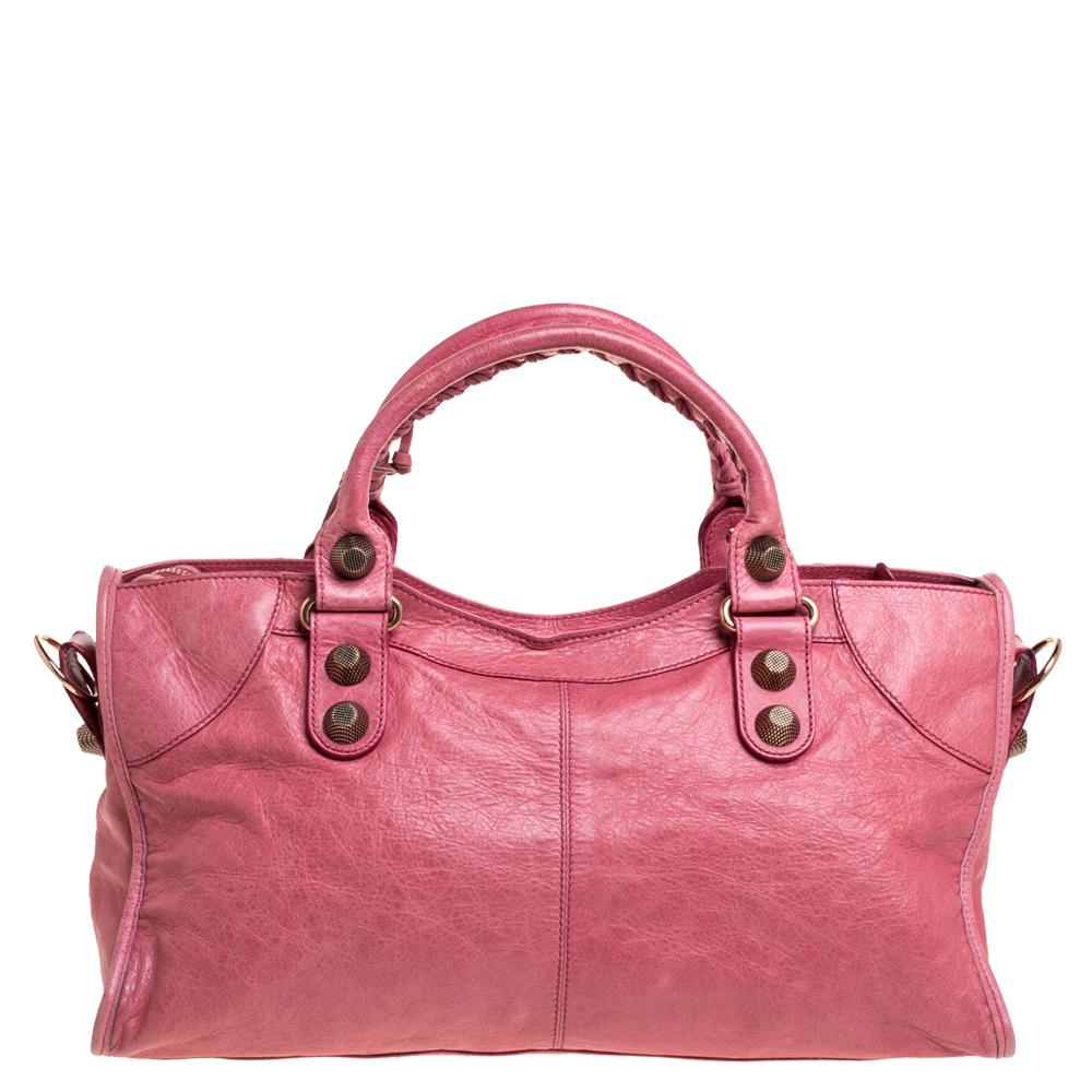 This Balenciaga Part Time tote is perfect for everyday use. Crafted from leather in a gorgeous pink hue, the bag has a feminine silhouette with two top handles, a removable shoulder strap, and rose gold-tone hardware. The zipper closure opens to a