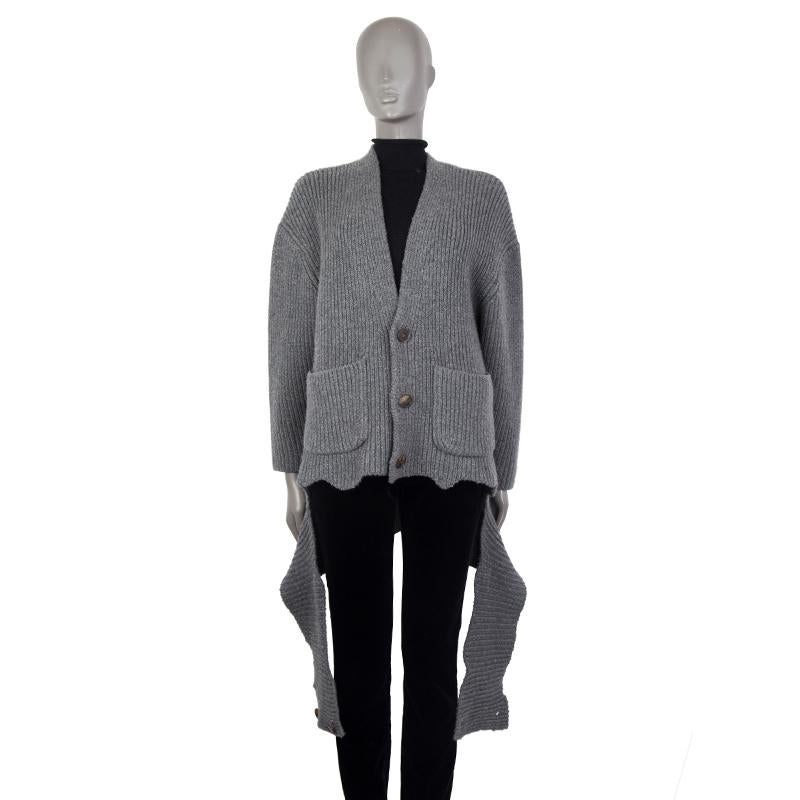 100% authentische Balenciaga übergroße, drapierte, gerippte Strickjacke aus grauem Kaschmir (96%), Nylon (2%) und Elastan (2%). Mit V-Ausschnitt, zwei aufgesetzten Taschen auf der Vorderseite und Schlitz vorne am Saum. Wird mit Hornknöpfen auf der