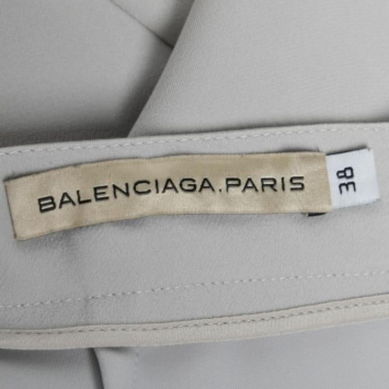 Cette mini-jupe de Balenciaga apportera une touche de féminité et de beauté à votre tenue. Elle est confectionnée en crêpe gris et rehaussée de formations plissées. Il est muni d'une fermeture à glissière au dos. Associez cette jupe à votre