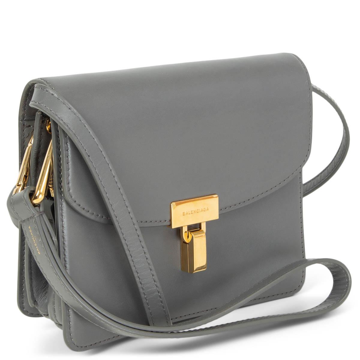 100% autentico Balenciaga Lock Shoulder Bag in pelle di vitello liscia grigia con finiture dorate. Si apre con una patta frontale ricurva e una serratura a rotazione per accedere a un interno foderato in pelle e diviso in due scomparti, uno dei