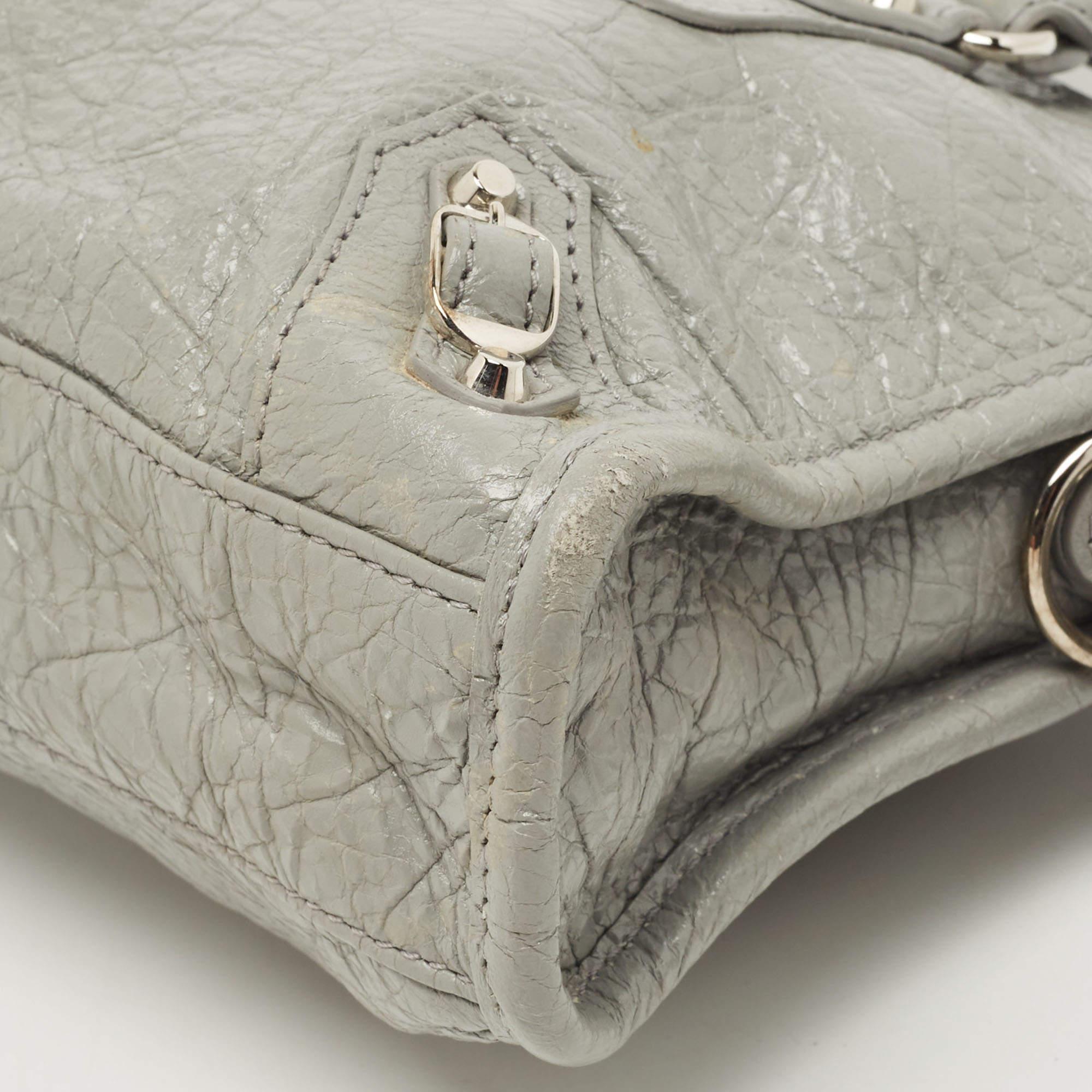 Presenting a stylish leather bag to own this season and the ones after. It has a grey exterior and a fabric-lined interior for all your essentials. A must-have in your collection, this bag from Balenciaga will represent your fabulous fashion