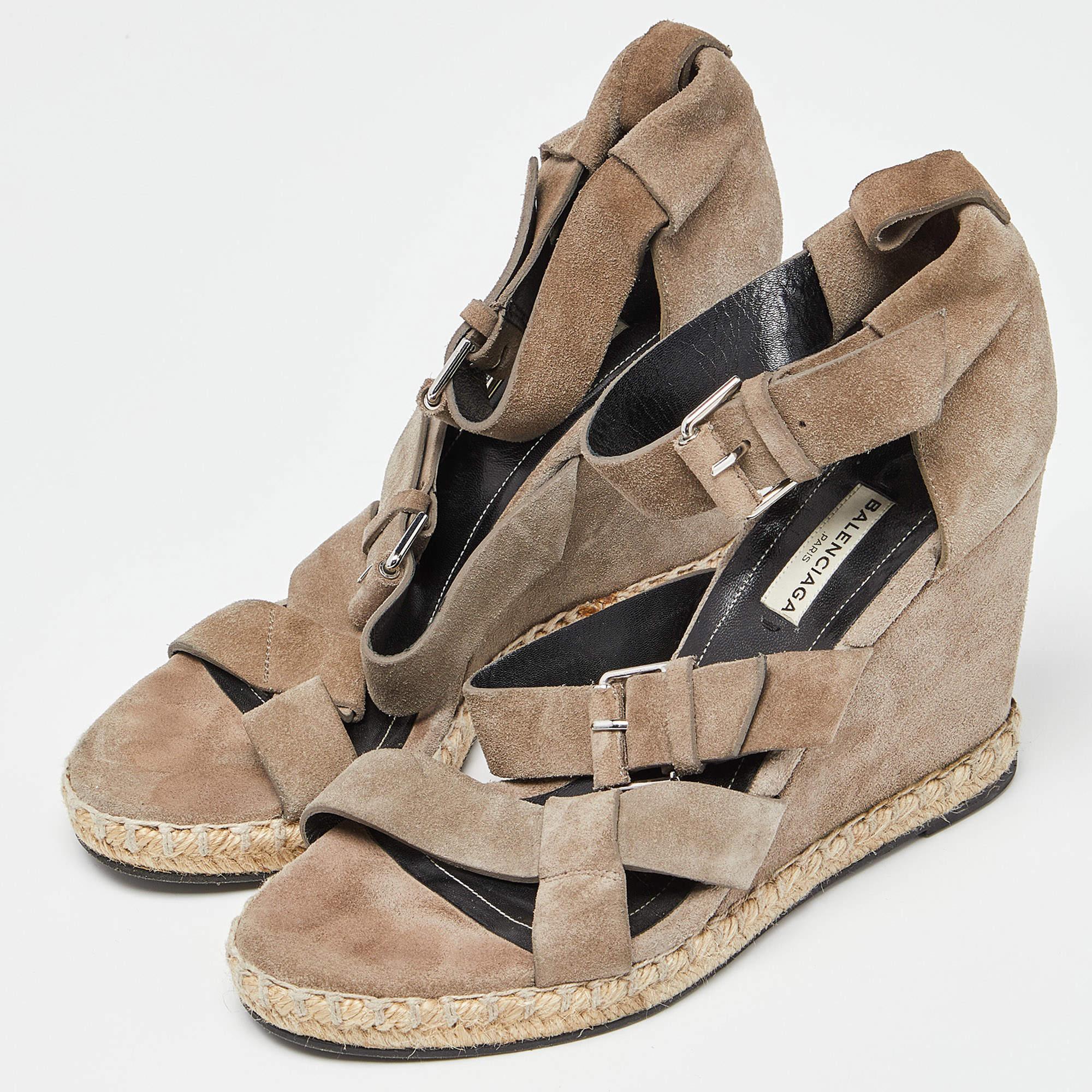 Encadrez vos pieds avec ces sandales compensées Balenciaga. Formées de brides en cuir vert, les chaussures sont parfaites avec des ourlets midi et maxi courts.